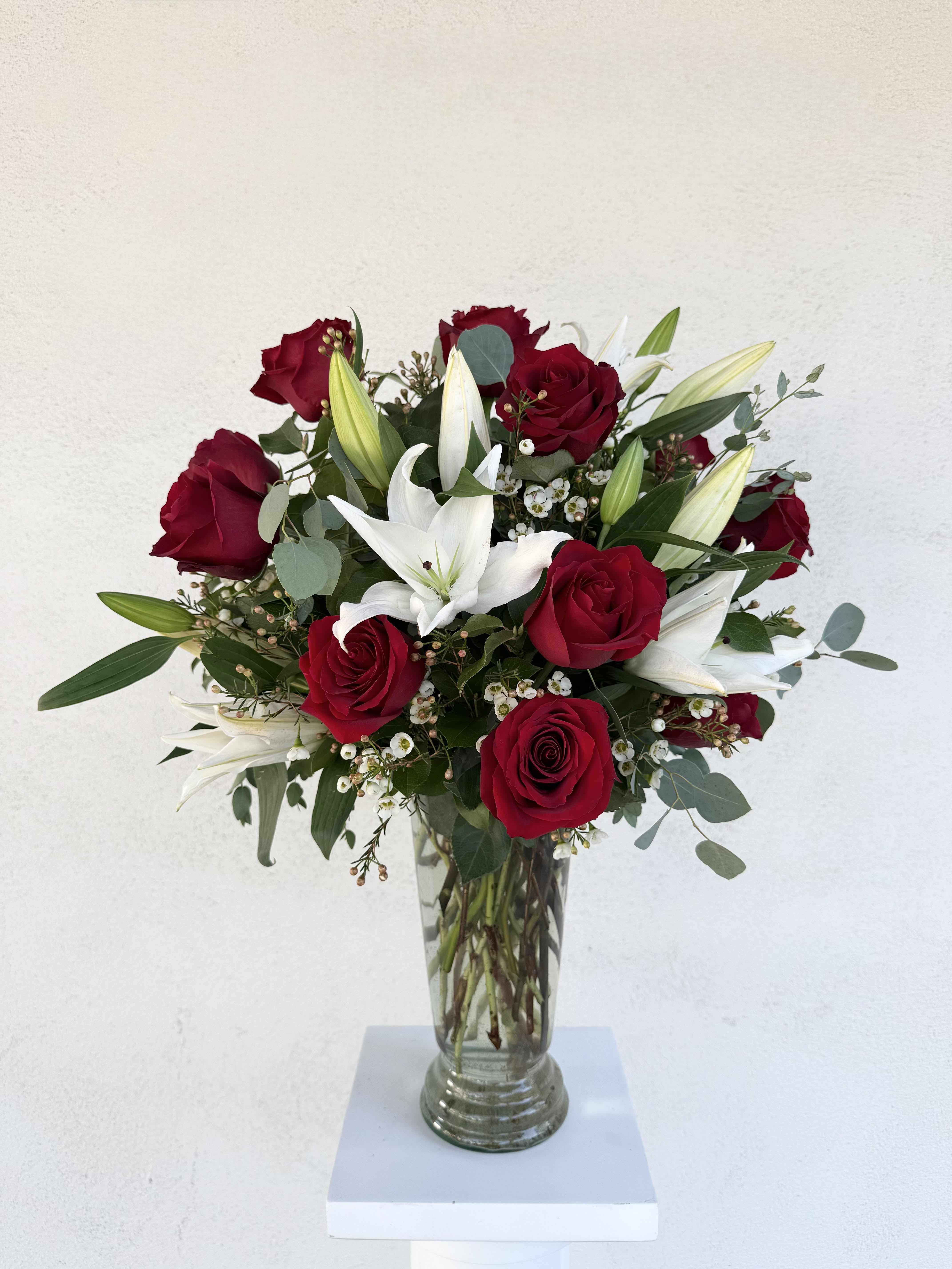 LF109 - Roses and Lilies Forever - A spectacular arrangement including a dozen beautiful long-stemmed red roses with white lilies and curly willow.  This arrangement says "I love you" with heartfelt intentions.  This is a large, grand statement of your love! Order the Deluxe and get 18 long stem roses with lilies.  Order the Premium and get 2 dozen long stem roses with lilies. Very large and grand. 