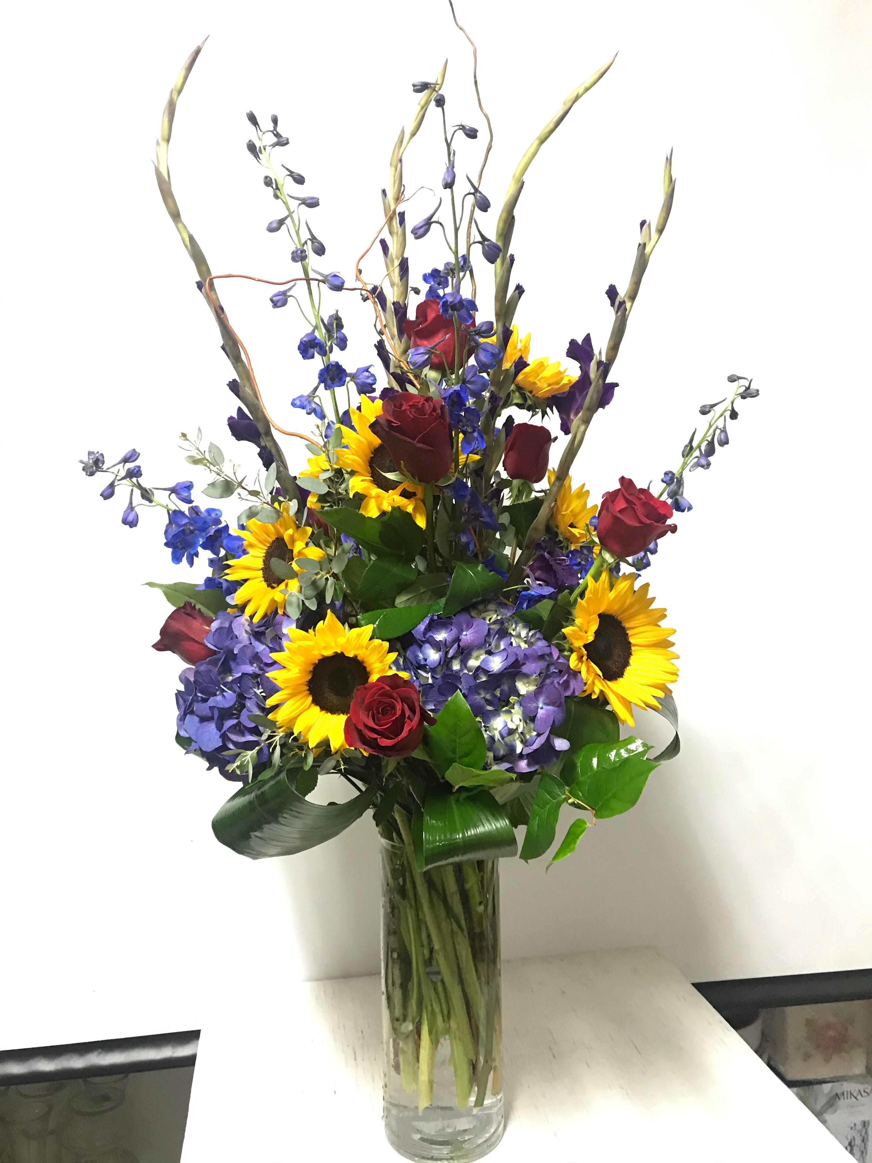 Birthday #20 - Arrangement of fresh cut flowers designed in a cylinder glass vase. Colors can be modified depending on availability.