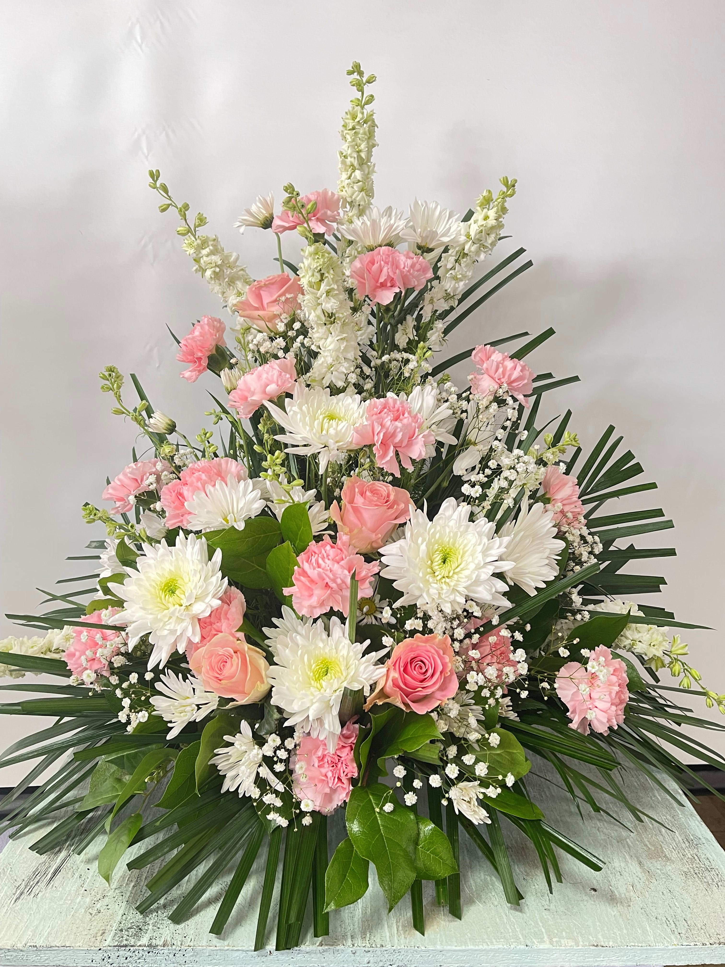 Sympathy #8 - Sympathy arrangement designed as a one sided style. Pictured in white and pink. Color can be modified depending on availability. Comes in a plastic container.