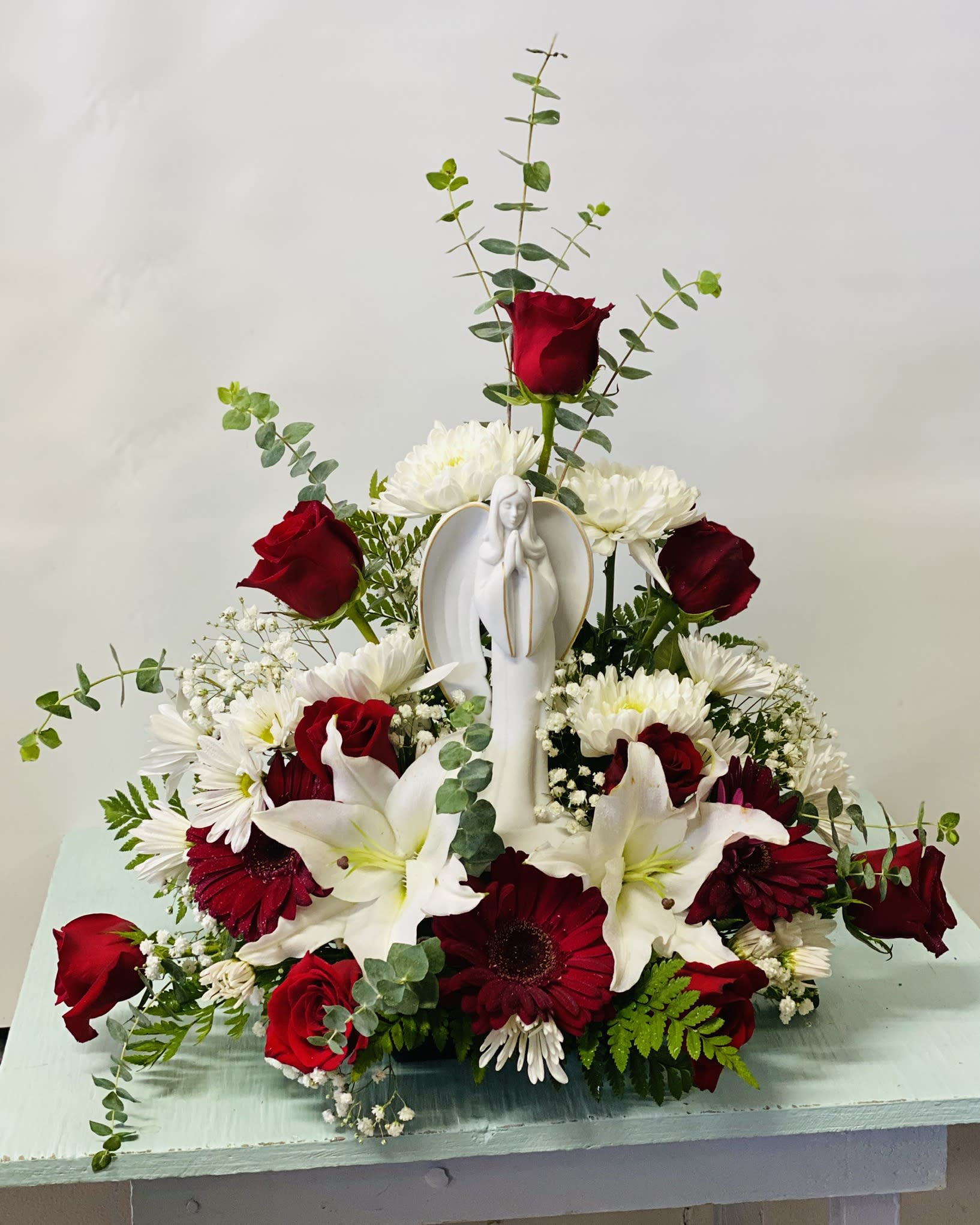 Sympathy Statue Arrangement #14 - Red and white arrangement which includes an angel statue. If statue is out of stock it will be substituted with a similar statue. Color can be modified depending on availability.