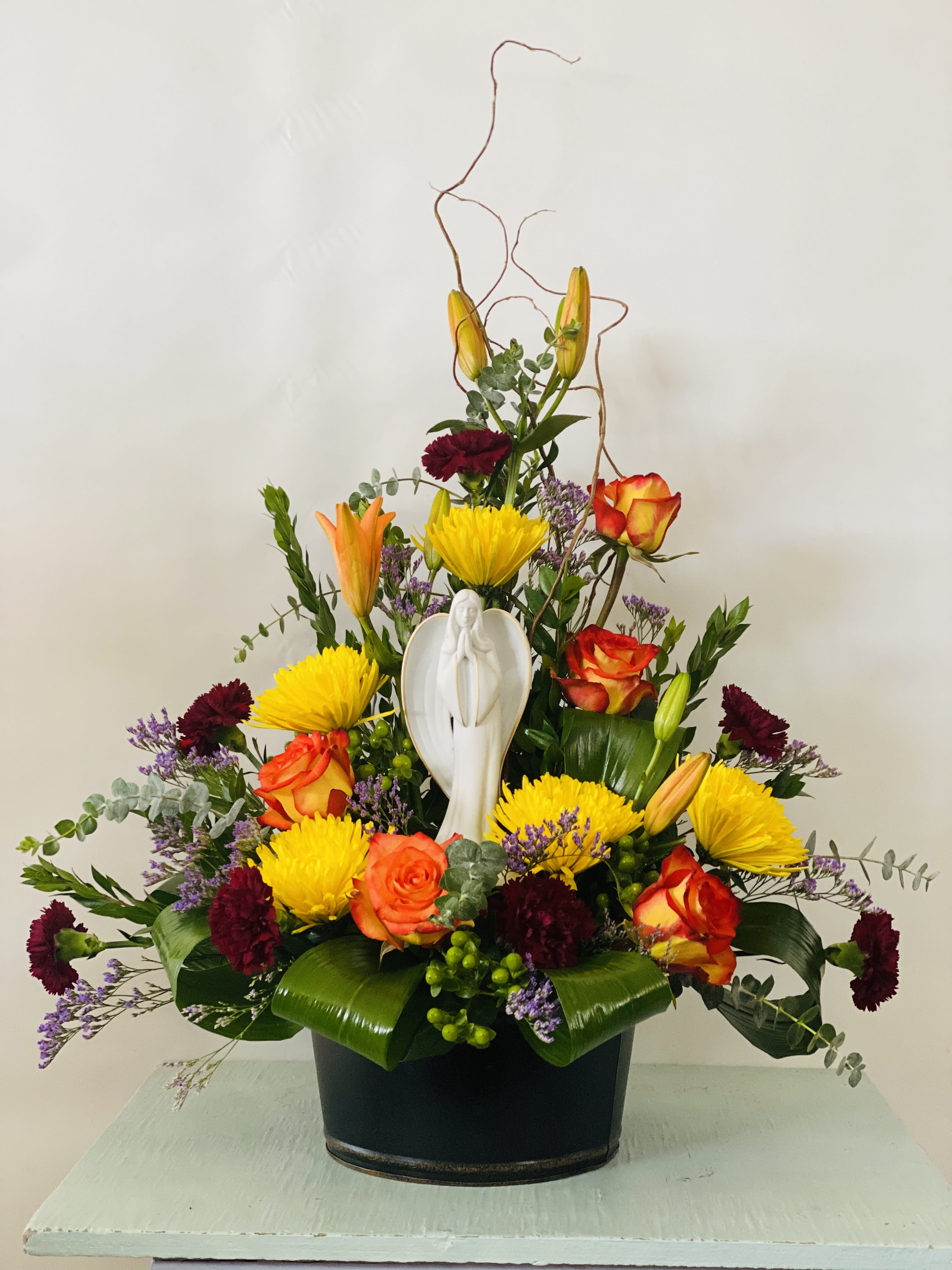 Sympathy Statue Arrangement #15 - Arrangement of fresh cut flowers in a black metal container with angel statue. If angel statue is out of stock it will be substituted with a similar angel statue. Color can be modified depending on availability.