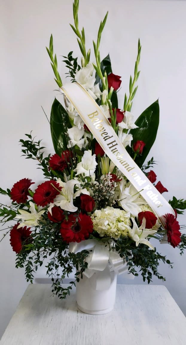 Sympathy #26 - Sympathy arrangement designed in white and red fresh cut flowers. Colors can be modified depending on availability. Banner is included with arrangement. Please specify what is to be printed on banner upon check out under "FLORIST INSTRUCTIONS". LIMITED TO 5 WORDS ON BANNER.