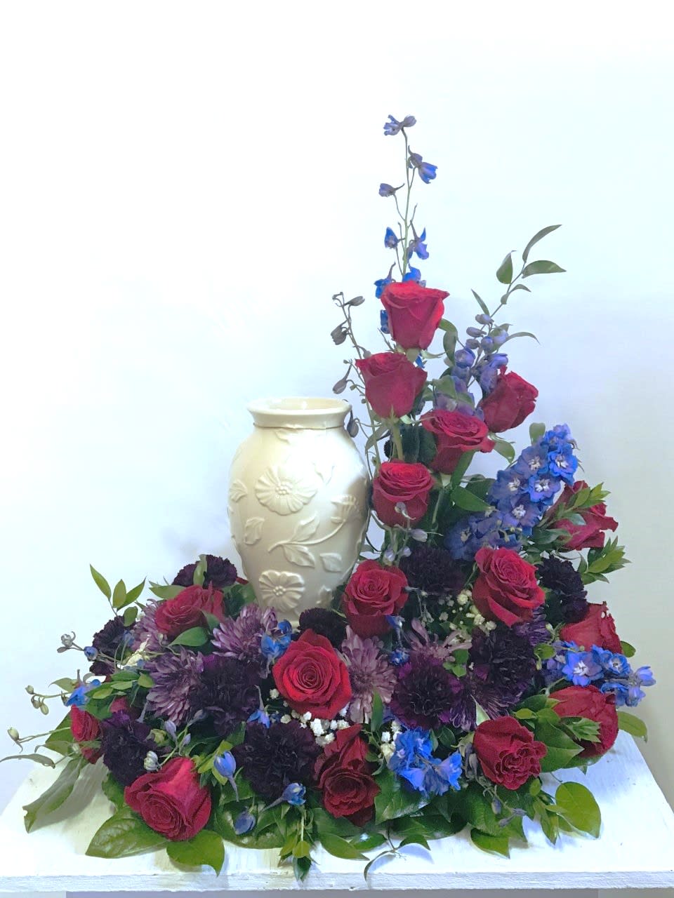 Sympathy Urn Arrangement #30 - Cremation arrangement. Vase not included only used as an example as to where urn will be placed. Arrangement designed in burgundy, red and blue colors. Colors can be modified depending on availability.