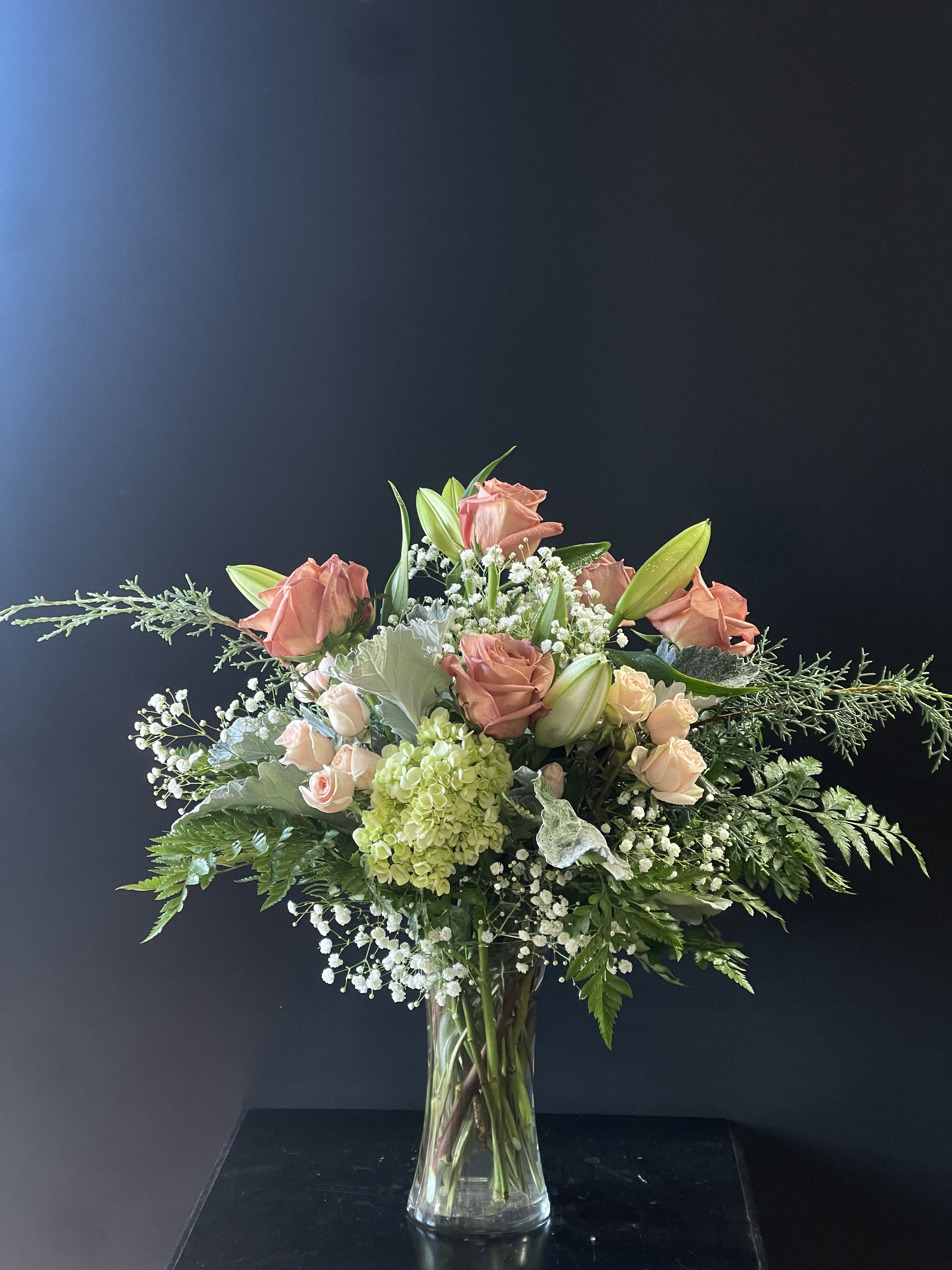 Dancing Queen - An elegant arrangement filled with roses, spray roses, baby's breath, lilies, and green hydrangeas.