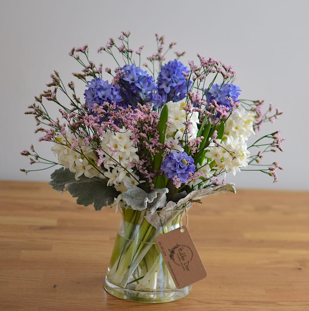 Danubius - Introducing the mesmerizing "Danubius" arrangement, inspired by the Latin name of Europe's majestic Danube River. This enchanting composition, gracefully presented in a glass vase, embodies a serene and rejuvenating presence that effortlessly transforms any space.  The Danubius arrangement features a delightful fusion of white and blue hyacinths, exuding a sense of tranquility and freshness. The elegant white blooms symbolize purity and innocence, while the delicate blue hues evoke a soothing and calming ambiance. As the fragrant petals unfurl, their sweet scent permeates the air, creating an immersive sensory experience.  Please note: hyacinth colors are subject to seasonal availability. If you require a specific color, kindly let us know at the time of ordering and we will do our best to accommodate your request.  Ideally suited for small spaces, the Danubius arrangement becomes a captivating centerpiece, adorning tabletops, desks, or cozy nooks with its refined beauty. Its compact size allows for effortless placement, making it an ideal choice for home or office environments where serenity is sought. The irresistible fragrance of the hyacinths lingers delicately, captivating the senses and inviting moments of relaxation and bliss. Each blossom is meticulously selected and expertly arranged, ensuring that the Danubius arrangement exudes a harmonious balance of visual appeal and olfactory pleasure.    