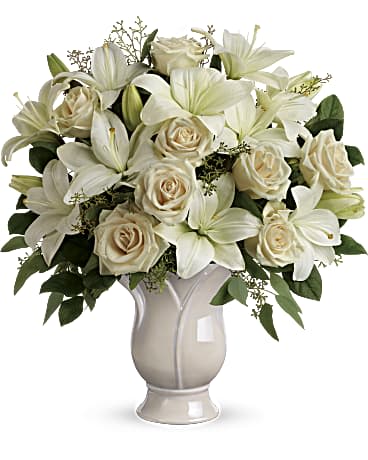 Teleflora's Wondrous Life Bouquet - An elegant expression of support and sympathy, this wondrous array of pure white roses and lilies conveys purity and peace. This monochromatic bouquet features crème roses, white lilies, seeded eucalyptus, and lemon leaf.