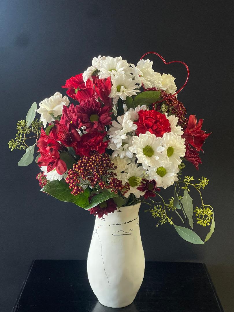 Promises Floral Arrangement - This unique vase is a beautiful reminder...The writing on the vase "There is no place I'd rather be"  Filled with red and white flowers like daisies, yarrow, carnations, alstroemerias to make this a long lasting floral arrangement and hopefully, a long lasting relationship!