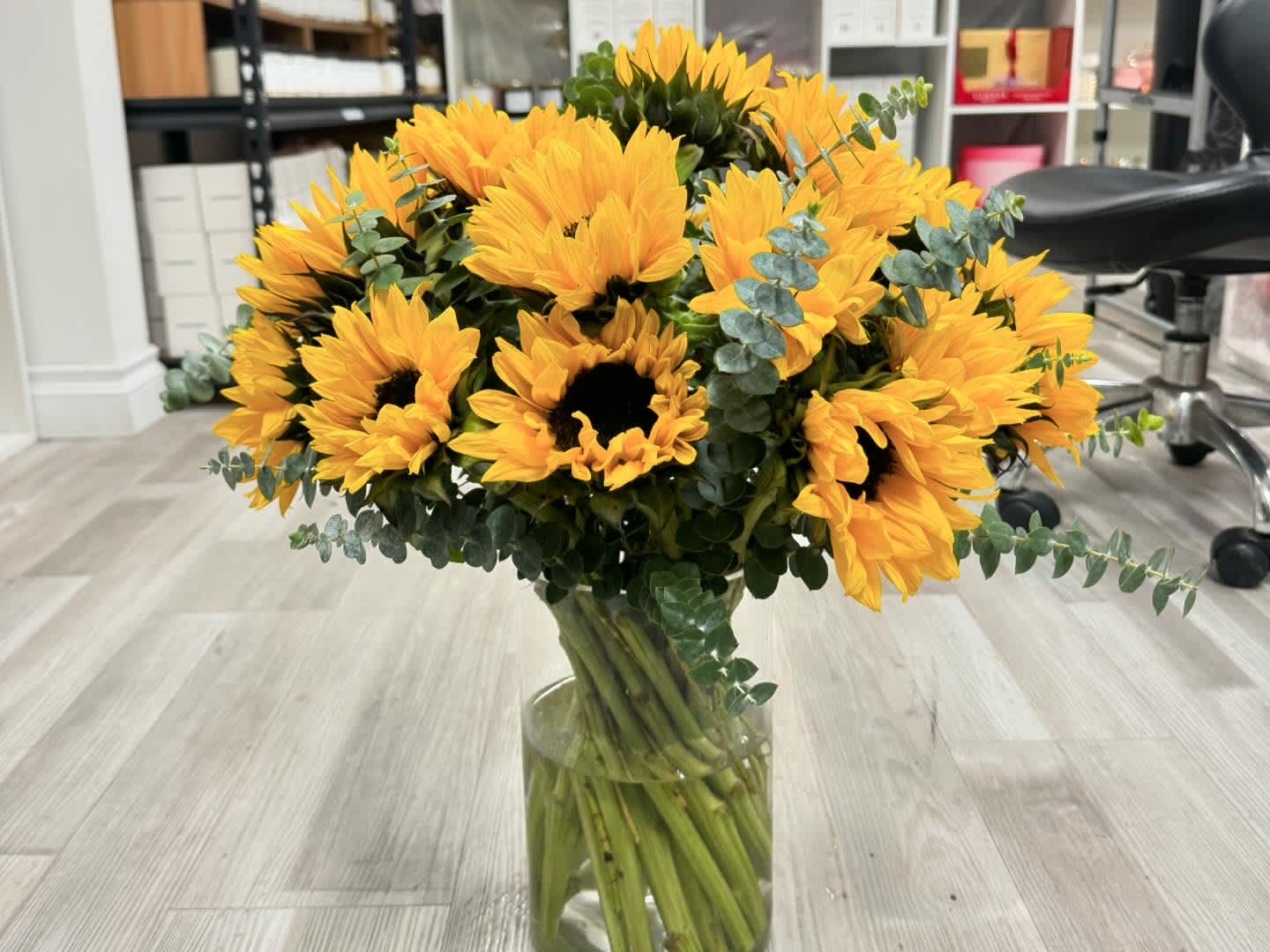 Sunflowers in a vase - A vase full of sunflowers for a special day. Depending on the size of sunflowers, the quantity will be varied on each order, equal or over 15 stems and eucalyptus. The size of vase is 5 inches wide and 8 inches tall.