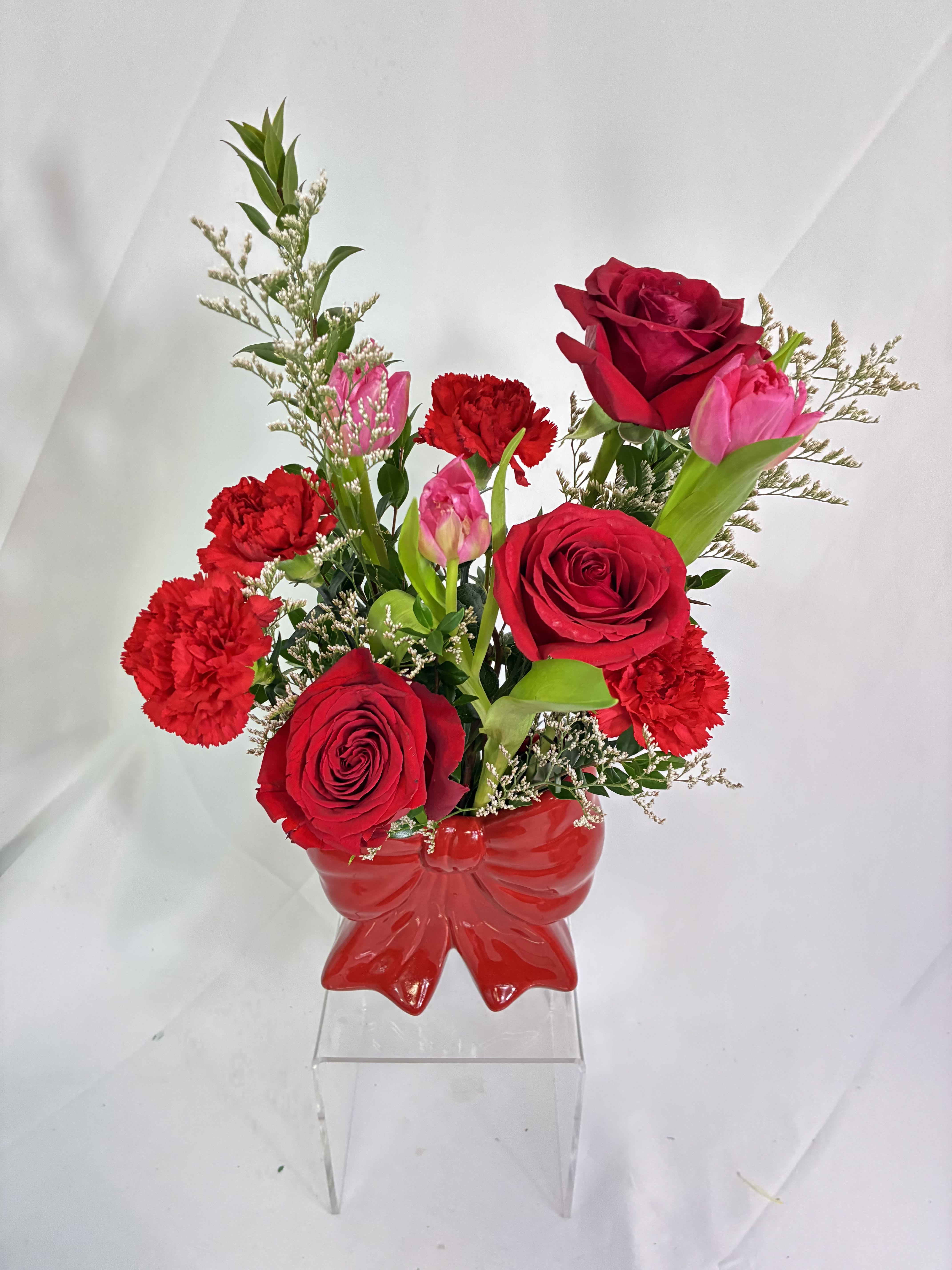 Tied up in Red  - This keepsake red, ceramic, bow vase holds a fresh, fanciful bouquet of Roses, Tulips &amp; Chrysanthemums. Does someone have your heart tied up with love? Send this precious gift to let them know! The darling vase will make memories along with the bouquet.