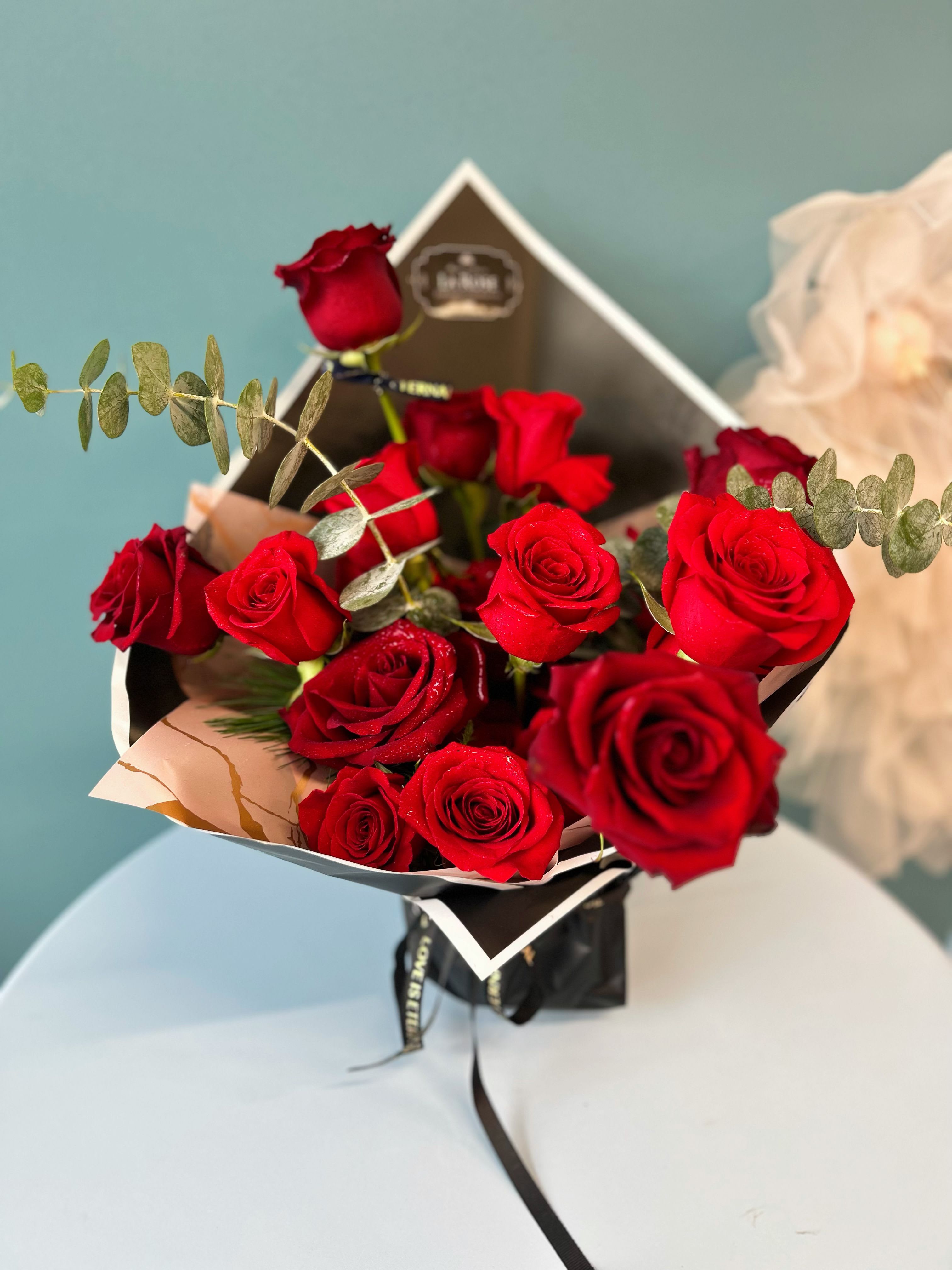 "LOVE is BOLD" Vase Bouquet - Turn heads with our Bold Vase Bouquet, featuring a vibrant mix of bold, eye-catching blooms in striking colors such as red, hot pink, orange, and more. Arranged with lush greenery in a designer’s choice vase, this bouquet is perfect for making a statement at any event or as a standout décor piece. Each arrangement is elegantly packaged to enhance its modern, bold appeal. Whether for a special occasion or to brighten up your space, this bold bouquet is sure to leave a lasting impression.  standard size:  10-12 preiumum roses or mix florals deluxe size:  16-18 premium roses or mix florals  Leave us a note at checkout with your preferred color theme and floral variety. While we cannot guarantee an exact match, we will make every effort to design your arrangement as closely as possible to your request.