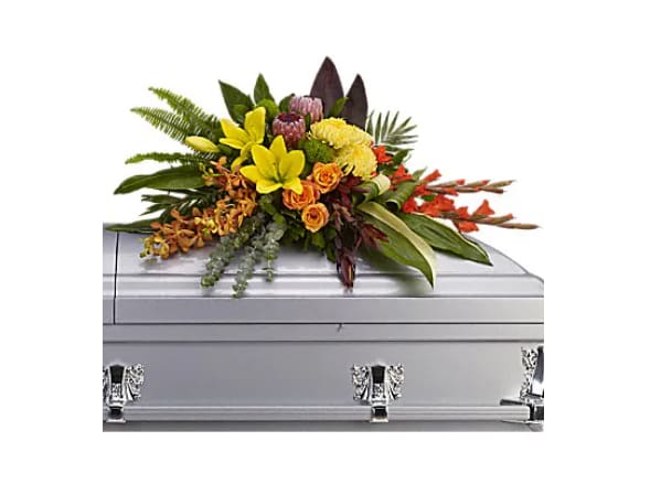 Island Memories Casket Spray - "Graceful and fresh, this tropical-influenced spray sheds light on memories that will be forever treasured. Splashed with color and grounded with earth tones, it lends comfort and hope to any memorial. Yellow asiatic lilies with orange orchids and roses, red gladioli, pink protea and yellow chrysanthemums are draped across the casket amidst radiating ferns, greens and leaves.   Orientation : N/A  All prices in USD ($)  Standard  T244-3A"