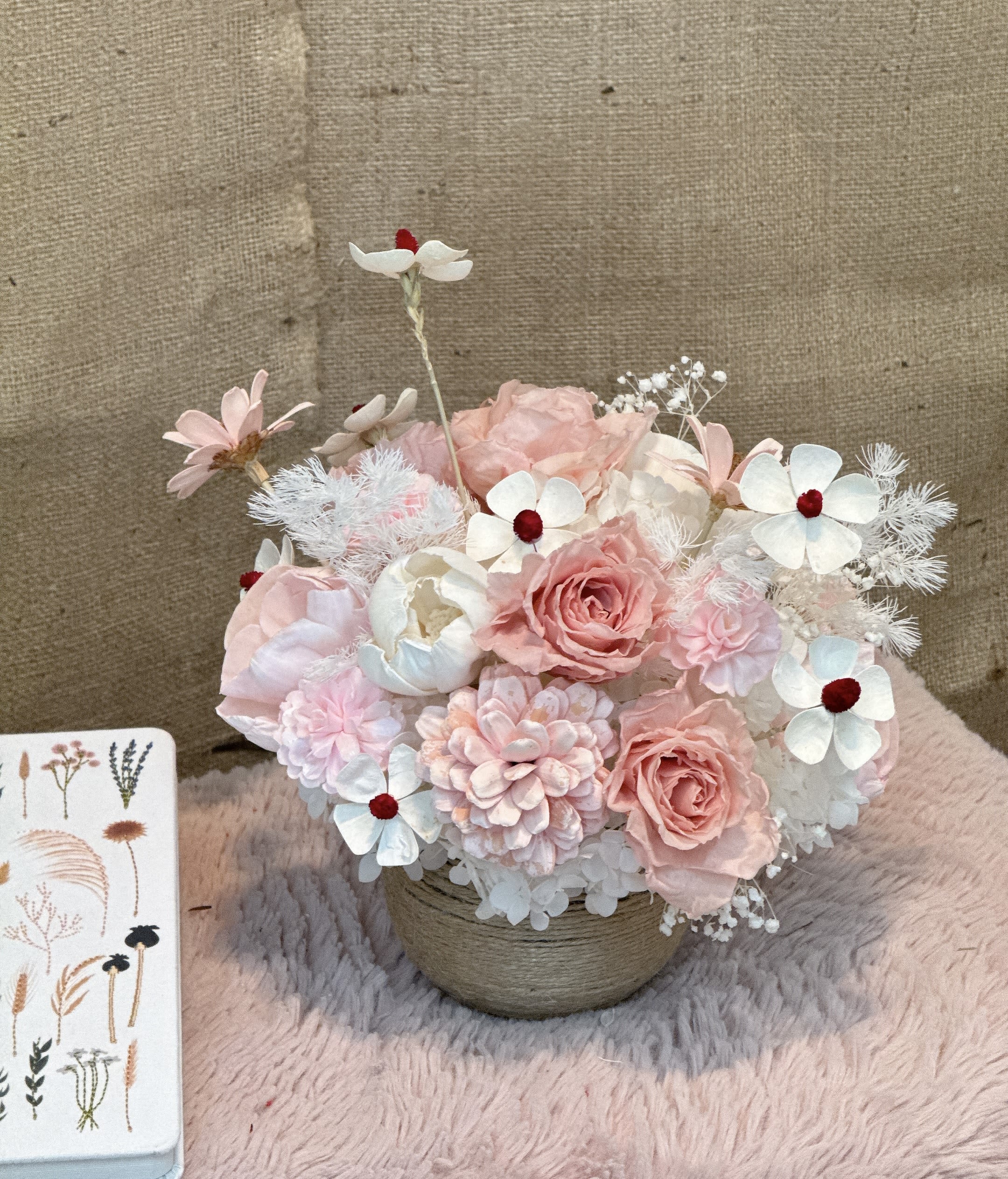 Sweet Harmony - This is a very beautiful flower art work. The bouquet is mainly in pink and white, including a variety of flower materials such as pink roses, pink peony, white pompom flowers and white small daisies, with red flower cores, adding a finishing touch.