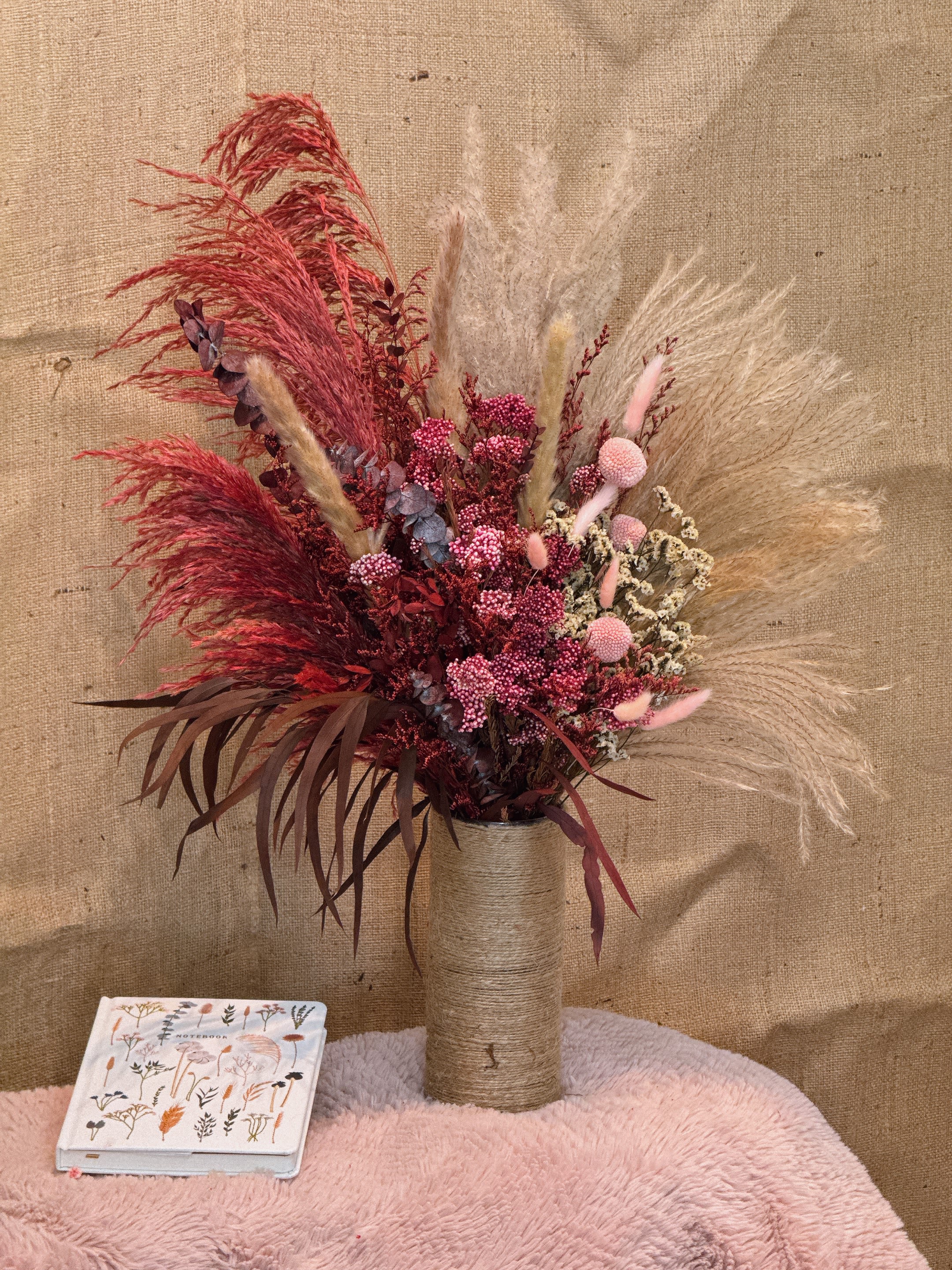 Earthbound Bloom - With red and pink as the main colors, with golden-brown dried grass and leaves, this one creates a warm and layered visual effect. The flowers include red feathery plants, pink flowers (such as full of stars), purple flowers and brown reeds. The overall style is natural and textured.