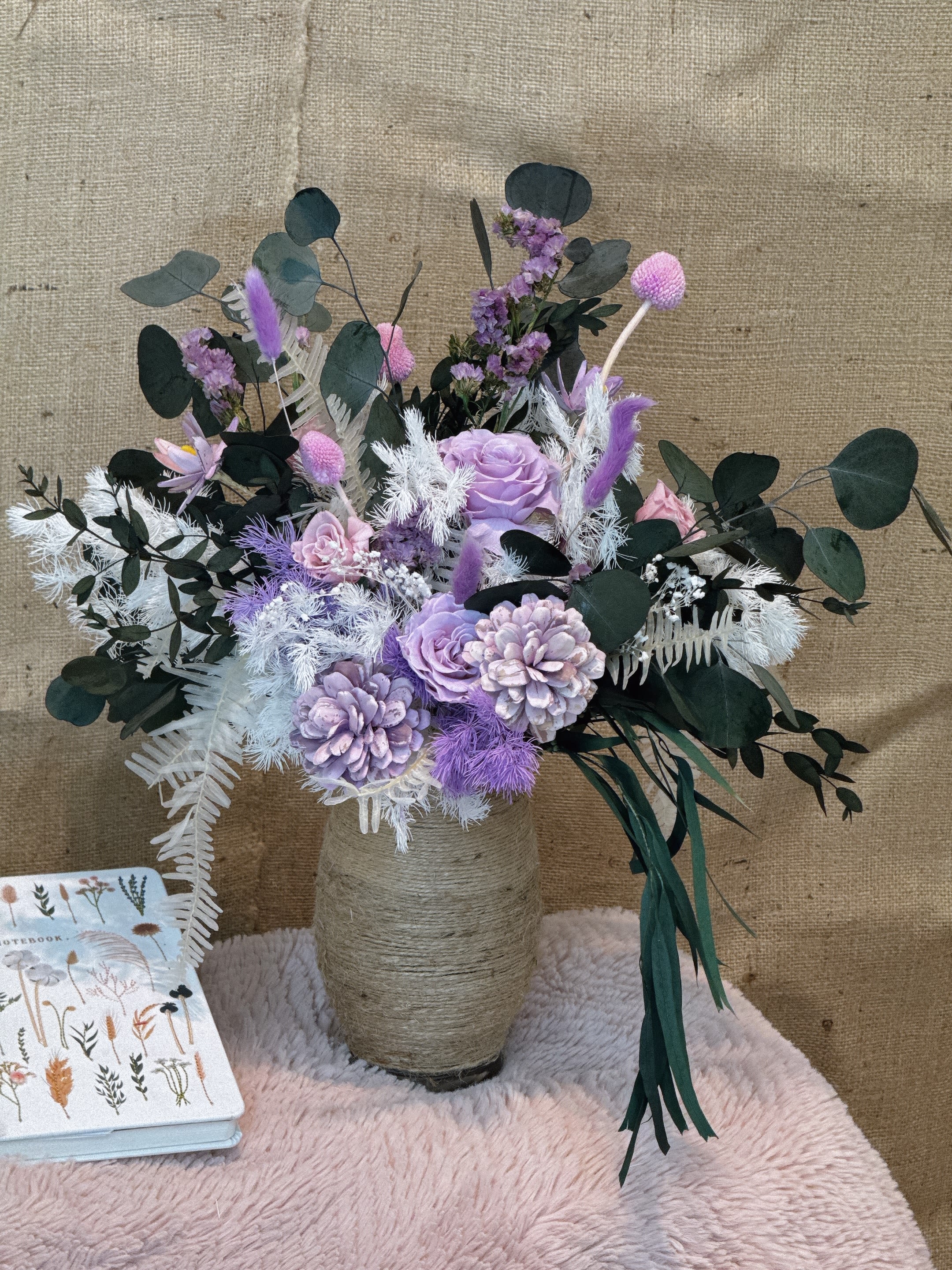 Emerald Lavender - This vase is arranged with purple, pink and white flowers with turquoise leaves, creating a fresh and elegant atmosphere. The vase adopts a rustic design wrapped with coarse twine, adding a touch of natural texture. This vase is suitable for home decoration or as a gift, especially on festivals or special occasions, which can add a romantic and warm atmosphere.