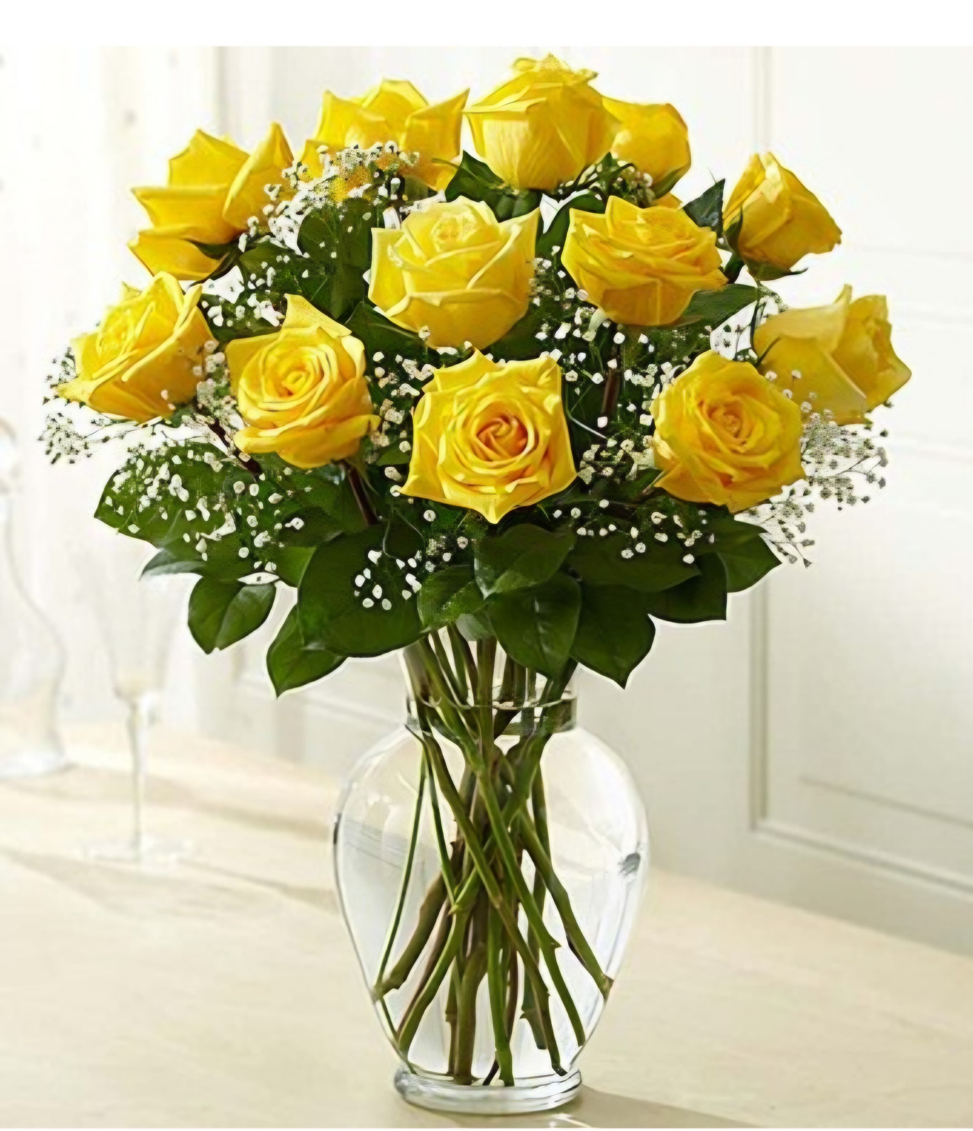 Classic Yellow Roses - 1 dozen beautiful classic yellow roses accented with baby's breath and greenery. Arranged tall in a clear glass vase vase.