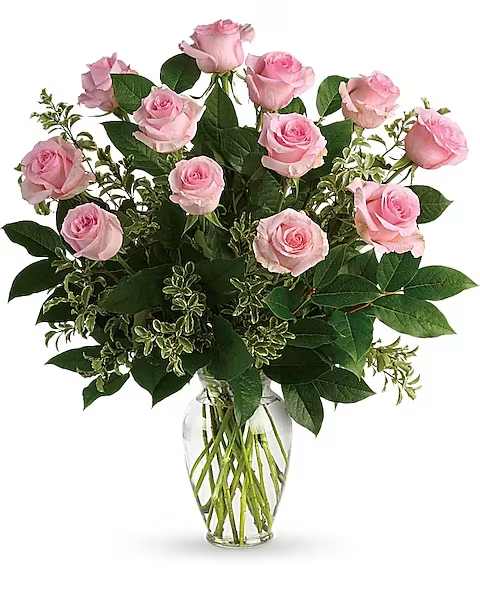 Say Something Sweet Bouquet - Say it sweeter with this feminine bouquet of a dozen ballet pink roses and lush greens in a graceful glass vase. 12 pink roses are arranged with pitta negra and lemon leaf. Delivered in a clear glass vase.   Orientation : All-Around  All prices in USD ($)  Due to an increase in the cost of roses, some product prices may be impacted during the Valentine’s delivery period.