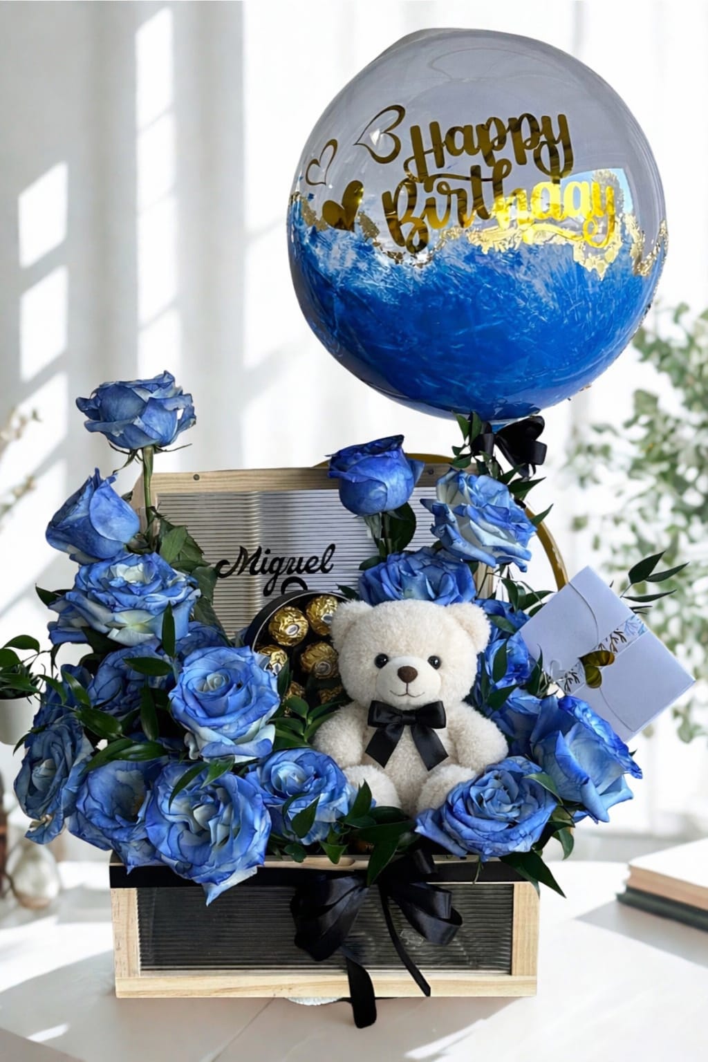 Miguel - Blue roses in a box with a teddy bear and chocolates with a personalized balloon