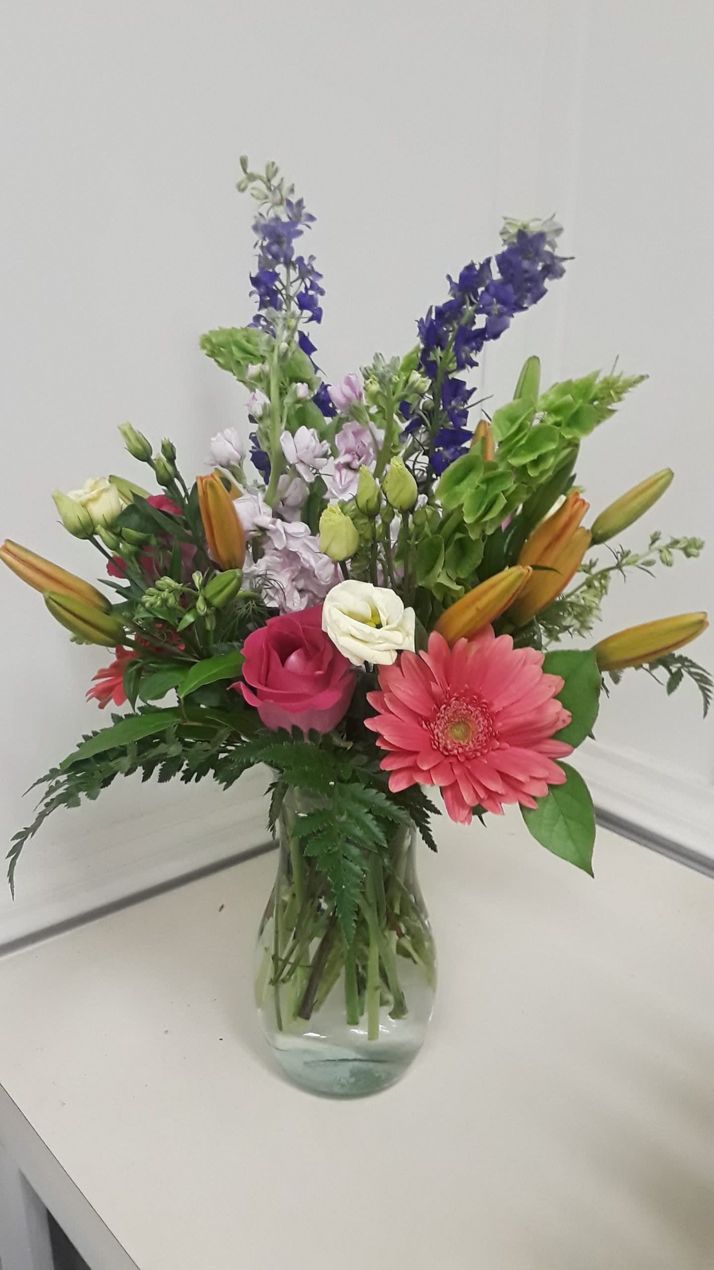 Island Wildflower - Beautiful arrangement of wildflowers, containing lilies, gerbers, greenery, and stock. Perfect for an any day and any occasion.  Containers will vary.