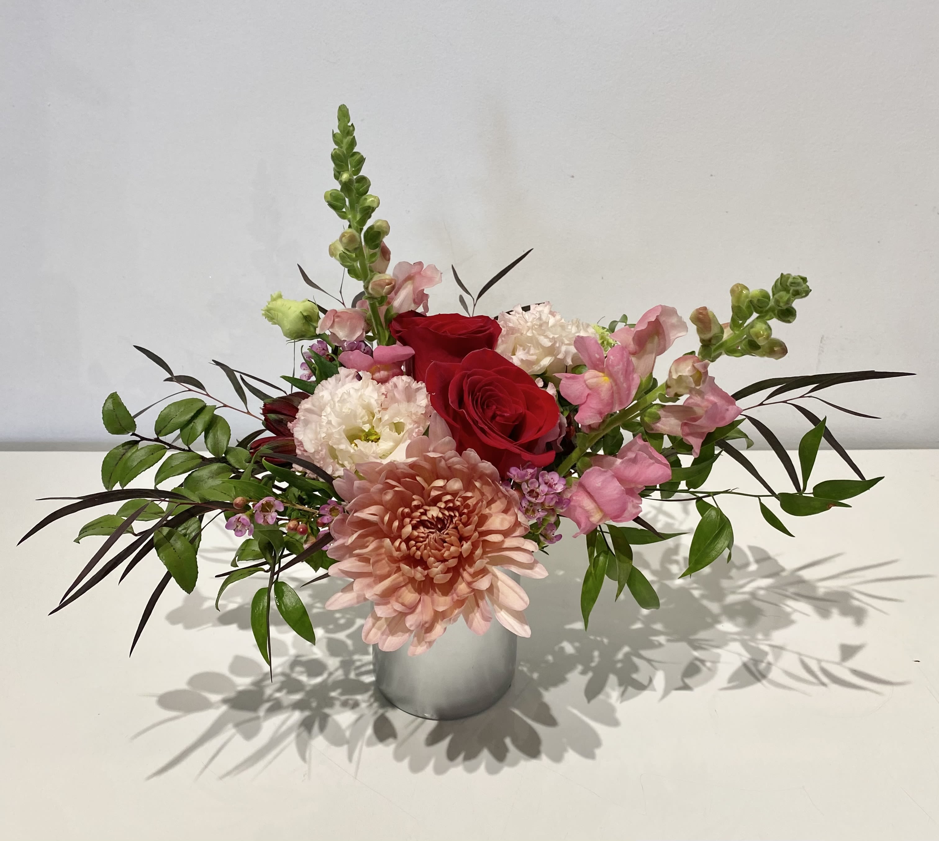 Be My Valentine  - A glass cup holding an array of fresh cut Florals in seasonal colors. Mix of Mums, Roses, Alestro, and Button Pom adorned with sprigs of green and pine, make the perfect gift to say "Be My Valentine”. 