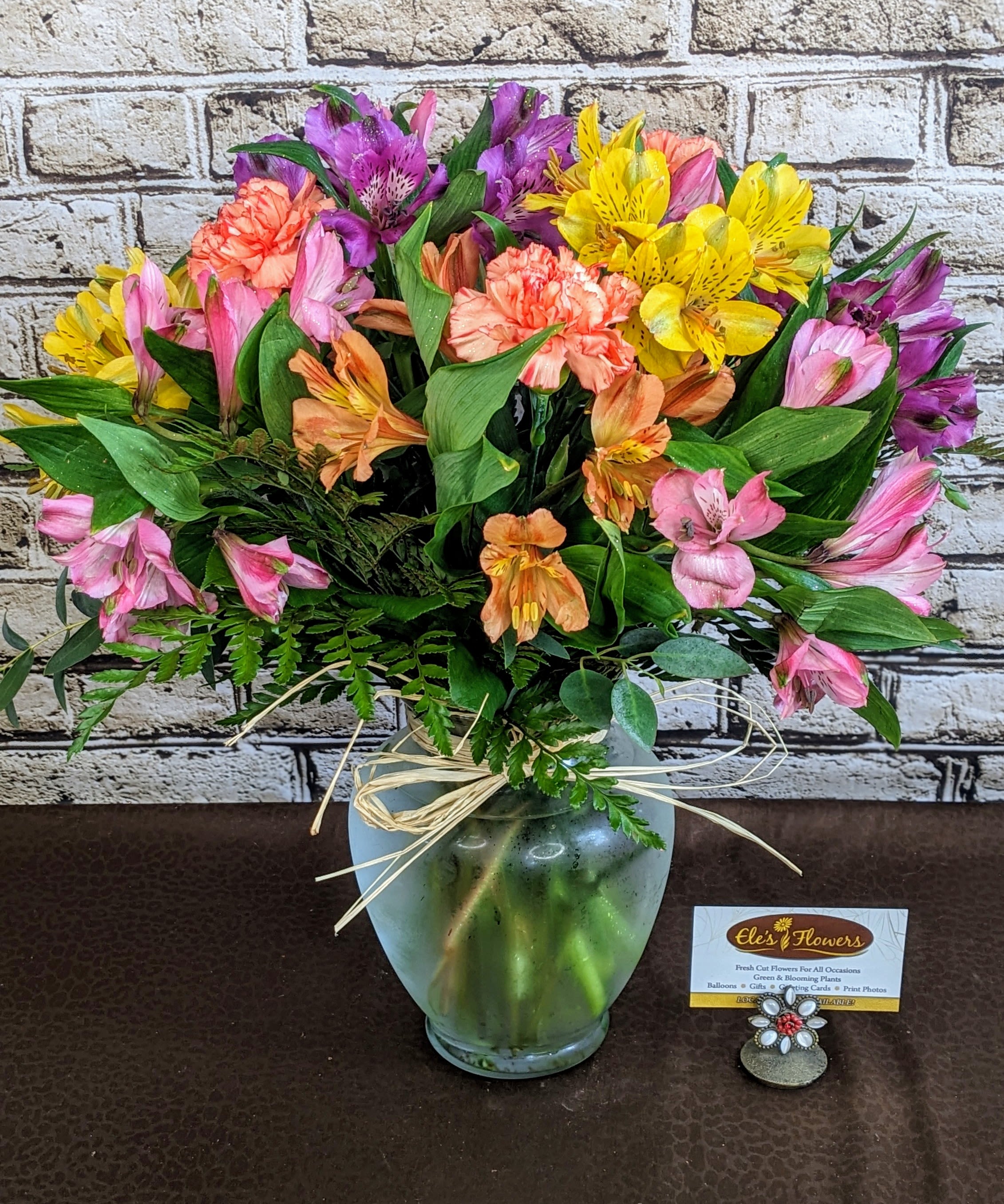 Awesome Alstroemeria  - Our Awesome Alstroemeria floral arrangement is a vibrant and cheerful display that showcases the delicate, trumpet-shaped blooms of alstroemeria, also known as Peruvian lilies. Available in a wide range of colors—from soft pastels like pink, peach, and white to bold hues like red, yellow, and orange—the arrangement offers a stunning mix of textures and shades. The flowers' distinctive speckled throats and multiple blossoms on each stem create a full, lush look. Arranged with carnations and complementary greenery such as eucalyptus or ferns, this bouquet exudes elegance and charm, making it perfect for brightening up any space or celebrating special occasions.  The designs we create are custom and the blooms and containers will vary. We use the freshest product available to create the perfect floral combination for the recipient. If you have any special requests, please add those in the "special instructions" portion of your order to help us dial in your vision. Otherwise, our skilled designers, Sara &amp; Brett, will take it from here!  This is a great sized arrangement for an island or kitchen table.   Approximate Dimensions: 14"H x 13"H 