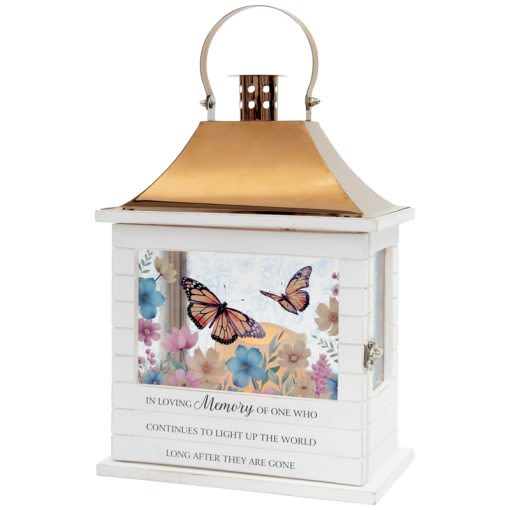 Light Up the World Slat Lantern with Butterflies - Our Wooden Slat lanterns are made with quality wood with a stainless steel finish top. They come inscribed with sentimental quotes amid beautiful artwork on all four sides and a charming flameless LED candle. Suitable for hanging or use as a freestanding item. Recommended as an accent in floral arrangements for many occasions. They are weather friendly! 3 AAA batteries are included. W: 8 3/4" H: 12 1/2 " D: 5 1/4 " Inscription reads," In loving memory of one who continues to light up the world long after they are gone."