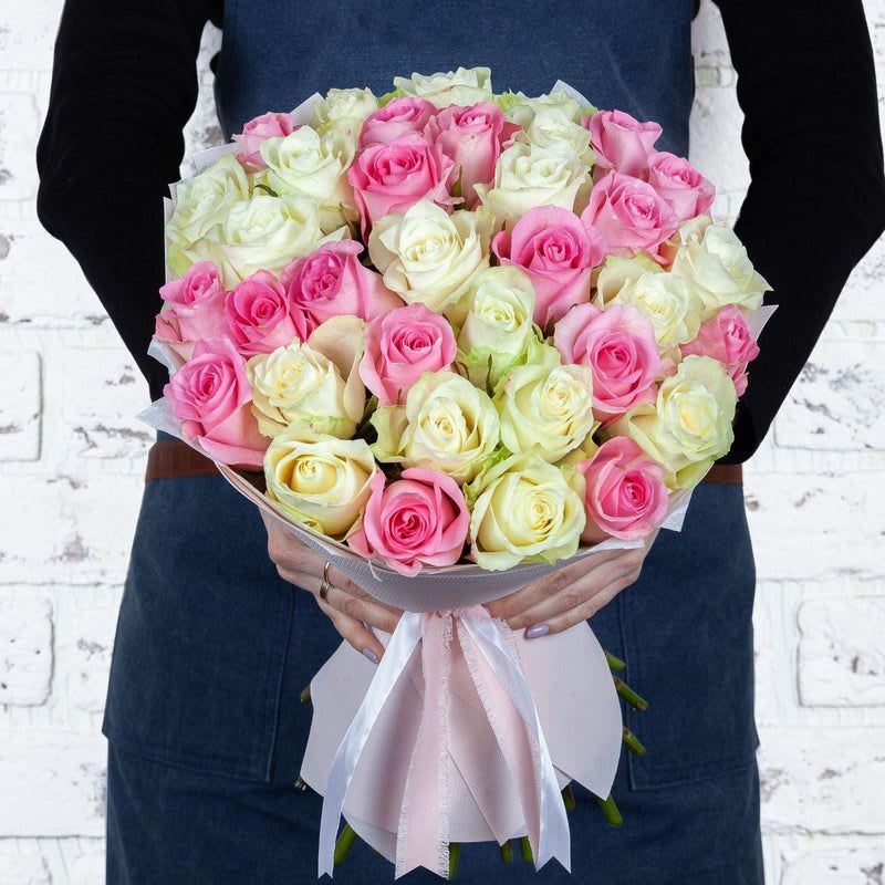 Joy &amp; Beauty - Introducing our exquisite hand-tied bouquet, a stunning celebration of love and beauty! This enchanting arrangement features a delightful mix of pure white and soft pink roses, symbolizing purity and affection. Each bloom is expertly selected for its freshness and elegance, creating a breathtaking display that captures the essence of nature's charm.  Wrapped in luxurious pink paper and elegantly tied with a delicate bow, this bouquet is not only a feast for the eyes but also a heartfelt gift for any occasion. Whether you're expressing your love, celebrating a special moment, or simply wanting to brighten someone's day, this beautiful bouquet is sure to leave a lasting impression.  Perfect for weddings, anniversaries, or simply to show someone you care, our hand-tied bouquet is a timeless gesture that conveys your sentiments effortlessly. Bring joy and beauty into your loved one's life with this stunning floral masterpiece!