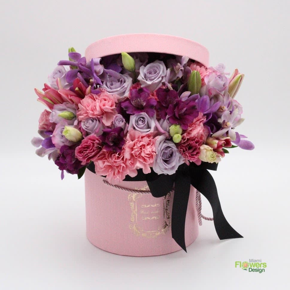 Pink Dreams - This is a unique perfectly mixed bouquet of purple roses, pink carnations, orchids, alstroemeria and lisianthus in a pink box with an elegant black bow will bring sweet smiles to the lucky recipient. 