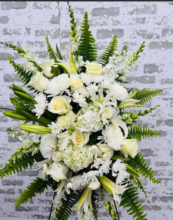 True Sympathy  - An all white tribute, this funeral spray is pure and tranquil. Featuring a variety of white flowers and green palms this elegant funeral spray brings a feeling of peace to it's surroundings   **Same Day- Please call to check for availability. 