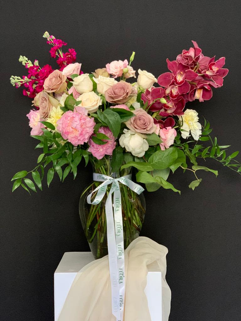 Organic Shape Arrangement with Roses, Peonies, Stock &amp; Cymbidium - Stunning organic shape arrangement featuring beautiful roses, peonies, stock, and cymbidium orchids. A unique and elegant design perfect for any occasion. Please note, some flowers may be substituted based on availability. Order this exquisite floral arrangement today!