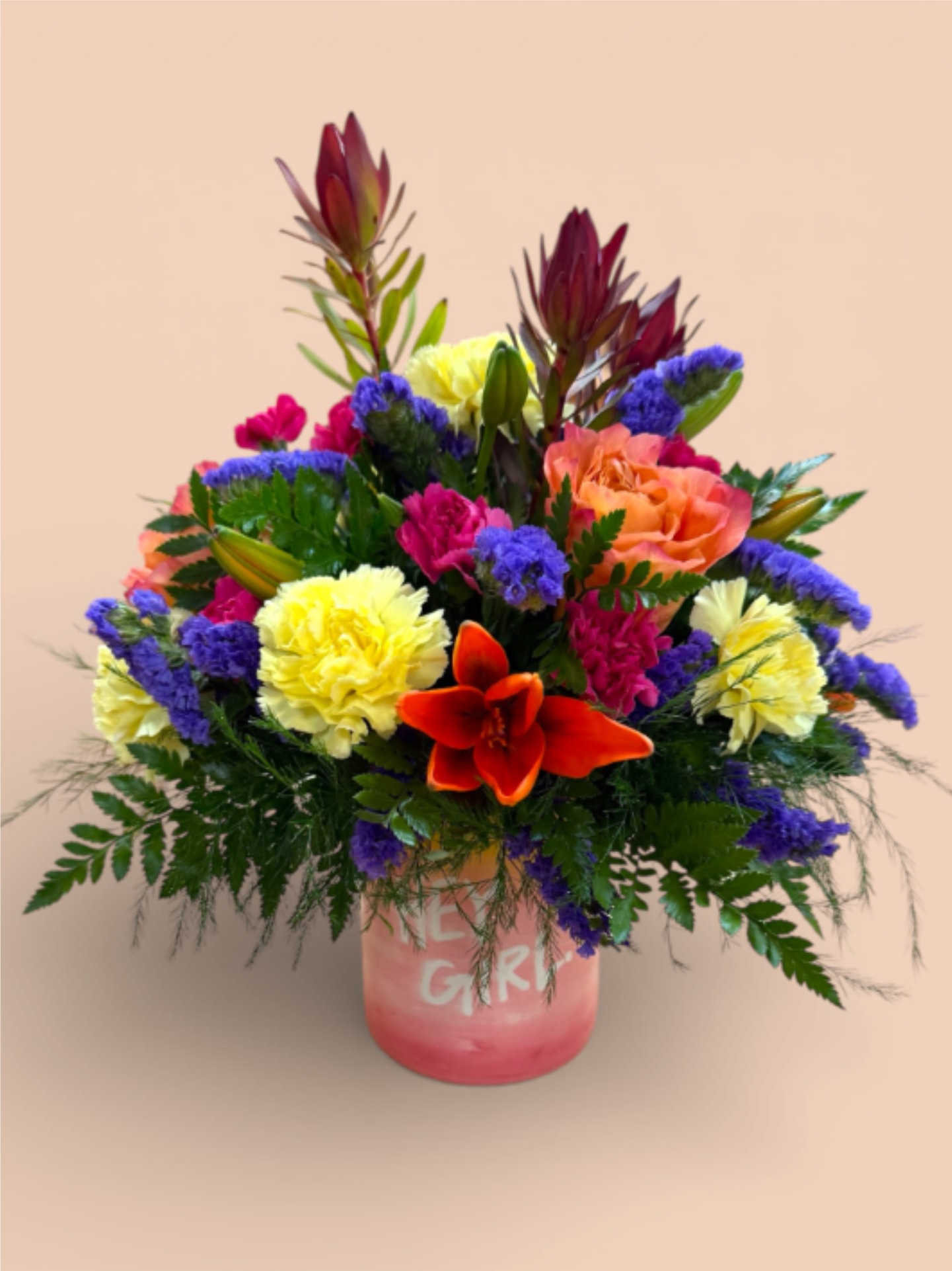 Sunset Blvd. - Our Sunset Blvd. arrangement is a vibrant tribute to iconic California sunsets, designed in a ceramic pot featuring the words “Hey Girl.” Bursting with orange lilies, hot pink and yellow carnations, orange roses, and rich purple filler, this eye-catching mix is playful, dramatic, and ready for its close-up