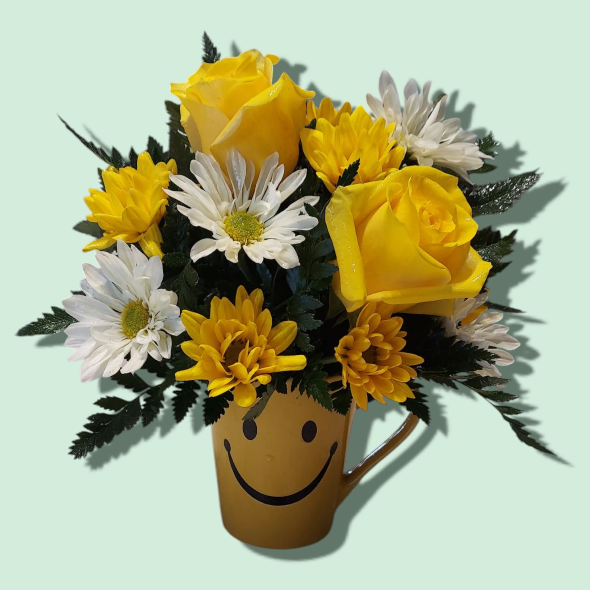 Sunshine Mug - Yellow and white daisies fill this smiley face mug with two roses nestled in between them. COLORS OF FLOWERS WILL VARY. STYLE OF SMILE MUGS WILL VARY. Approximate size: 8"H x 6"W