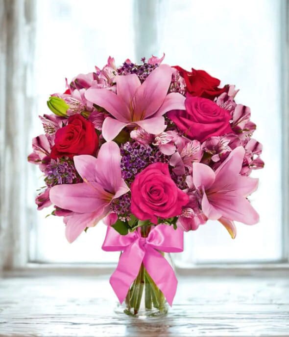 Rose &amp; Lily Celebration - Send stunning flowers to celebrate any occasion! With classic floral colors including red roses and pink lilies, the Rose and Lily Joy is a wonderful gift to send to a friend or family member for a birthday, get well, or anniversary. Paired with the flowers is a keepsake clear vase that is wrapped in a decorative ribbon.