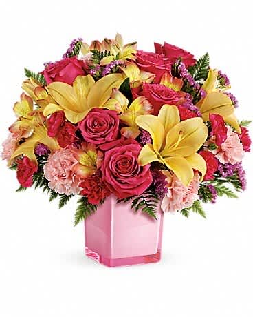 Teleflora's Pop Of Fun Bouquet - Turn up the fun! Make any day extra special with a surprise delivery of joyful blooms in a stylish cube vase. This bouquet of pink roses and luxurious peach lilies will make their mood soar! This fresh, fun mix of pink roses, peach asiatic lilies, peach alstroemeria, pink carnations and pink miniature carnations is accented with raspberry sinuata statice and leatherleaf fern. Delivered in a glass cube.