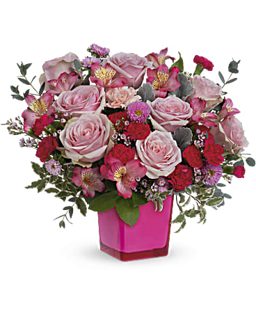 Teleflora's Rosy Moment Bouquet - Celebrate the special moments in life! This mix of cheerful pink roses and blooms in a keepsake fuchsia glass cube makes every moment magical. Pink roses, dark pink alstroemeria, pink carnations, miniature hot pink carnations and pink matsumoto asters are arranged with lemon leaf, pink waxflower, dusty miller and pitta negra. Delivered in a Color Splash cube.