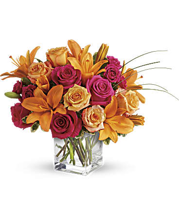 Teleflora's Uniquely Chic - Uniquely beautiful and uniquely bright, this is a bona fide bombshell of a bouquet. Brilliant blossoms are perfectly arranged in an exclusive cube vase. Orange roses, hot pink roses, spray roses and carnations are joined by glowing orange asiatic lilies and bear grass in a delightful vase. This unique arrangement is delivered in a cube but it's definitely not for squares.