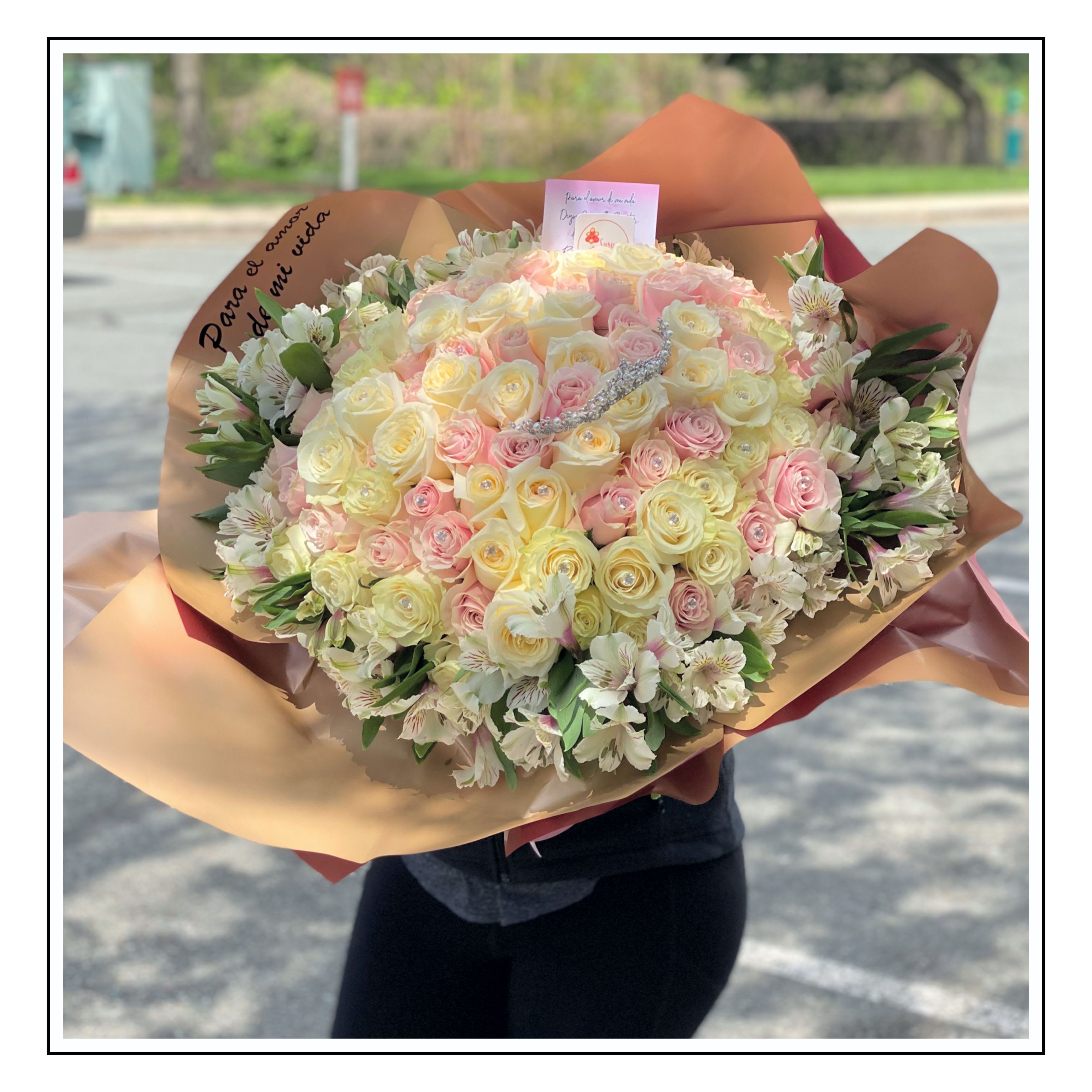 Aurora - Bouquet of 100 roses surrounded by alstroemerias, decorated with a crown, crystals, and a personalized message.  Bouquet de 100 rosas con acompañamiento de  astromelias a su alrededor, decorado con corona, cristales y mensaje personalizado. 