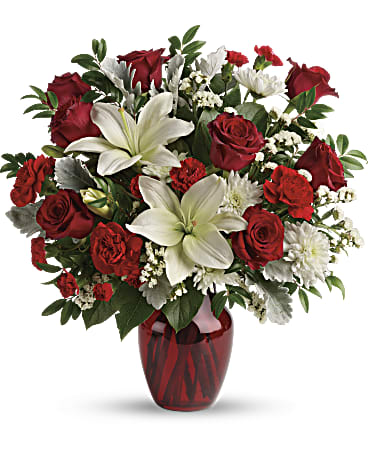 Visions Of Love Bouquet - A vision of love! This luxe bouquet of fragrant white lilies and radiant red roses, hand-delivered in a ruby vase, is the perfect expression of your feelings. This beloved bouquet includes red roses, white asiatic lilies, red carnations, red miniature carnations, white cushion spray roses, white sinuata statice, dusty miller, huckleberry, and lemon leaf. Delivered in a ruby rose vase.