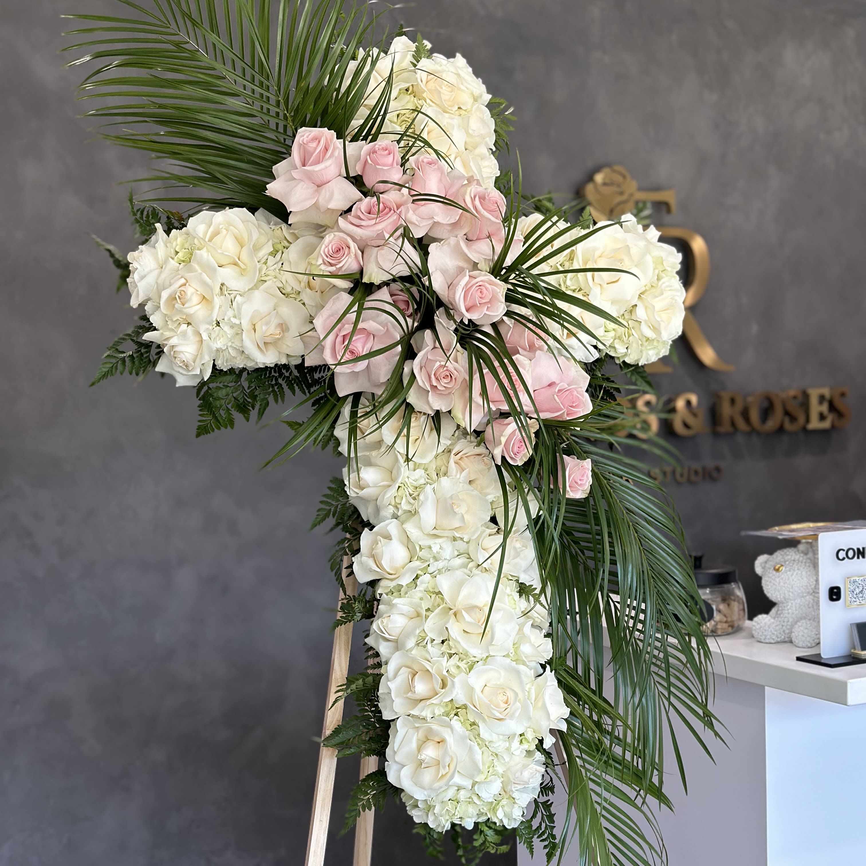 Cross of Remembrance - This elegant bouquet features approximately 50 fresh roses, beautifully arranged in the shape of a cross. A stunning tribute, it symbolizes faith, love, and remembrance, making it a meaningful choice for honoring a loved one. Perfect for a funeral service or memorial , this cross-shaped arrangement offers a timeless expression of sympathy and respect.