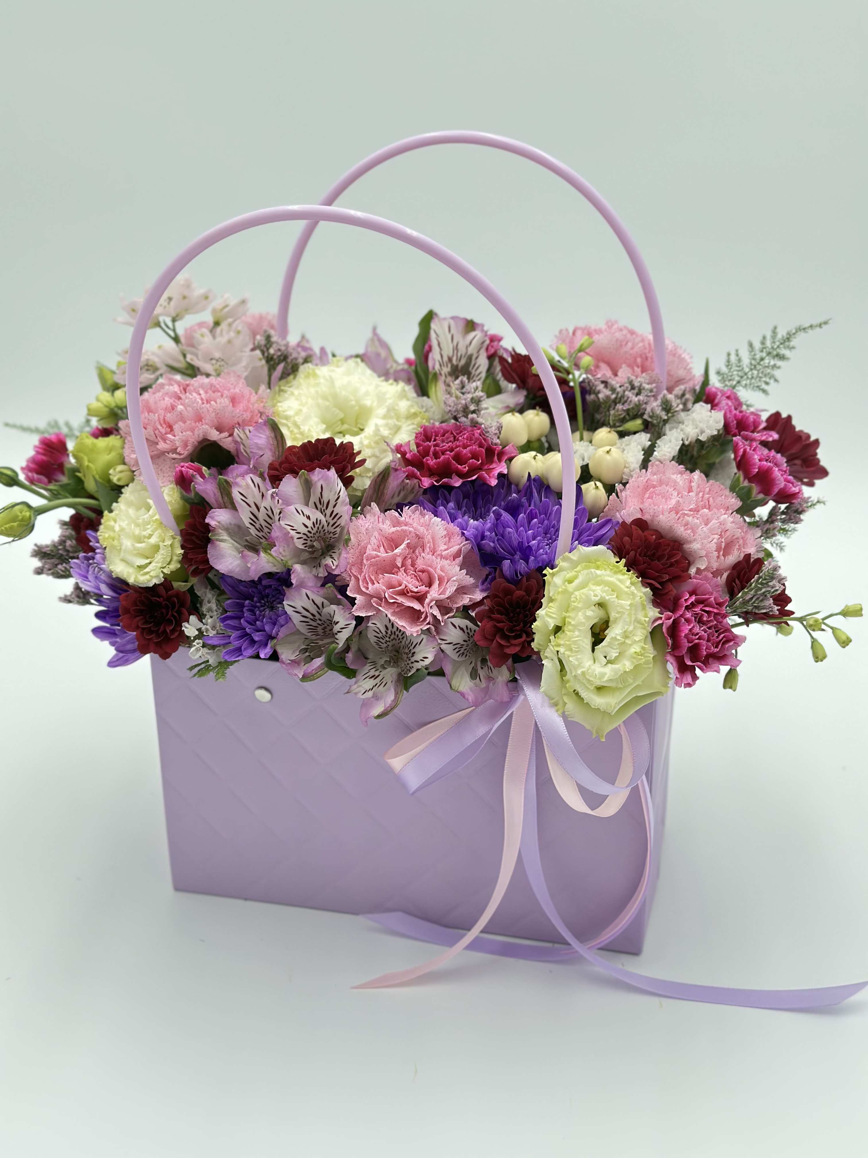 First Feeling - This arrangement in a handbag is made for those who appreciate elegance and softness in every detail. The subtle color transitions create a magical mood and bring a sense of calm. When ordering this arrangement, you will receive a composition in soft shades of color. Component substitutions are possible.
