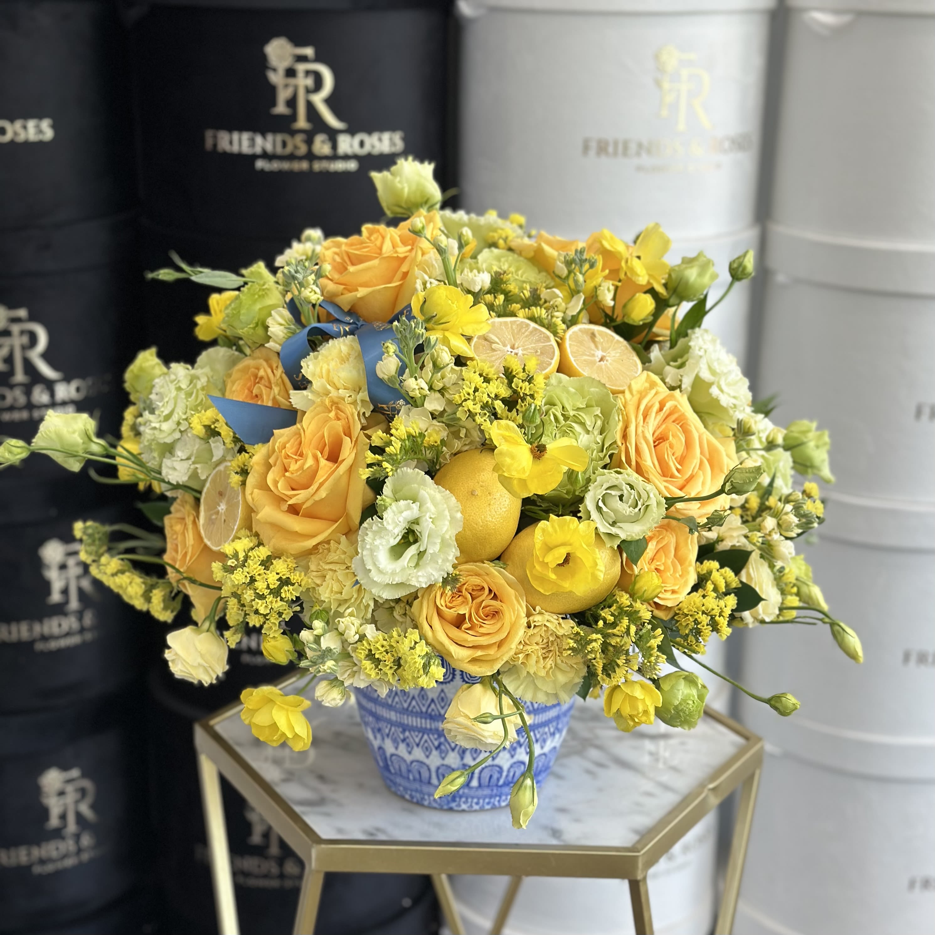 Lemon Zest - A vase filled with a vibrant yellow floral and fresh lemons provide a Mediterranean feel to it.