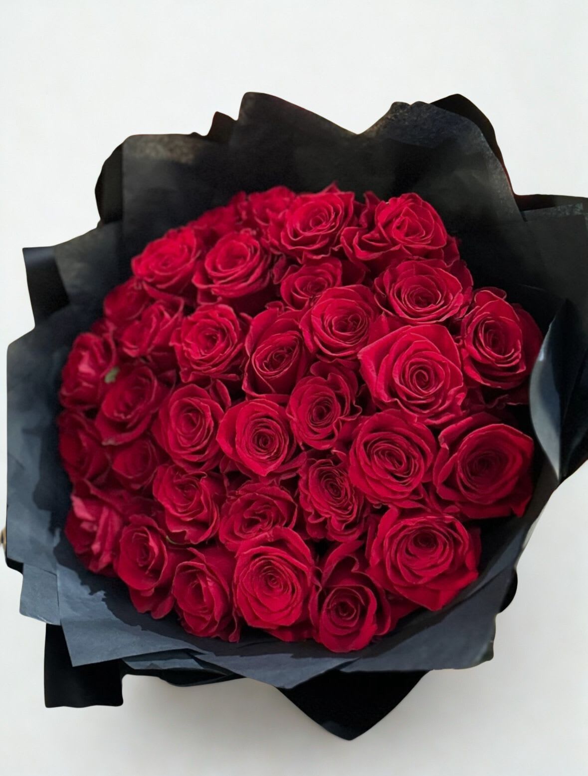 Midnight Romance  39 Red Roses - Thirty-nine rich red roses wrapped in dramatic black paper bold, modern, and straight to the point. This bouquet is made for anniversaries, date nights, apologies, and anyone who loves a clean, high-impact look. Includes: 39 premium red roses + luxury black wrap Note: Rose size may vary slightly by season, but the bouquet will stay full and striking.