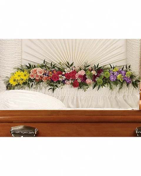 Glorious Memories Garland - Create a beautiful resting place with this magnificent garland of roses and other floral favorites artistically placed at the base of the casket lid. The exquisite arrangement includes hot pink spray roses, peach spray roses, light pink alstroemeria, pink miniature carnations, yellow daisy spray chrysanthemums, purple button spray chrysanthemums, green button spray chyrsanthemums, orange snapdragon, lavender stock and purple sinuata statice, accented with assorted greenery.   Orientation : One-Sided  All prices in USD ($)  Due to an increase in the cost of roses, some product prices may be impacted during the Valentine’s delivery period.
