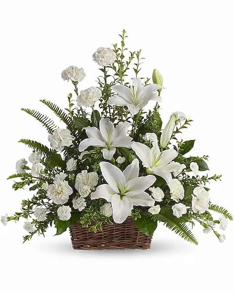 Peaceful White Lilies Basket - Whether you send this beautiful arrangement to the family home or to the service, all will appreciate its elegance and grace. The contrast of brilliant white blossoms and dazzling greenery create a wonderfully calm and dignified setting. Gorgeous flowers such as white lilies, carnations and miniature carnations mix with vibrant greens in a large basket. Simply stunning.   Orientation : One-Sided  All prices in USD ($)  Due to an increase in the cost of roses, some product prices may be impacted during the Valentine’s delivery period.