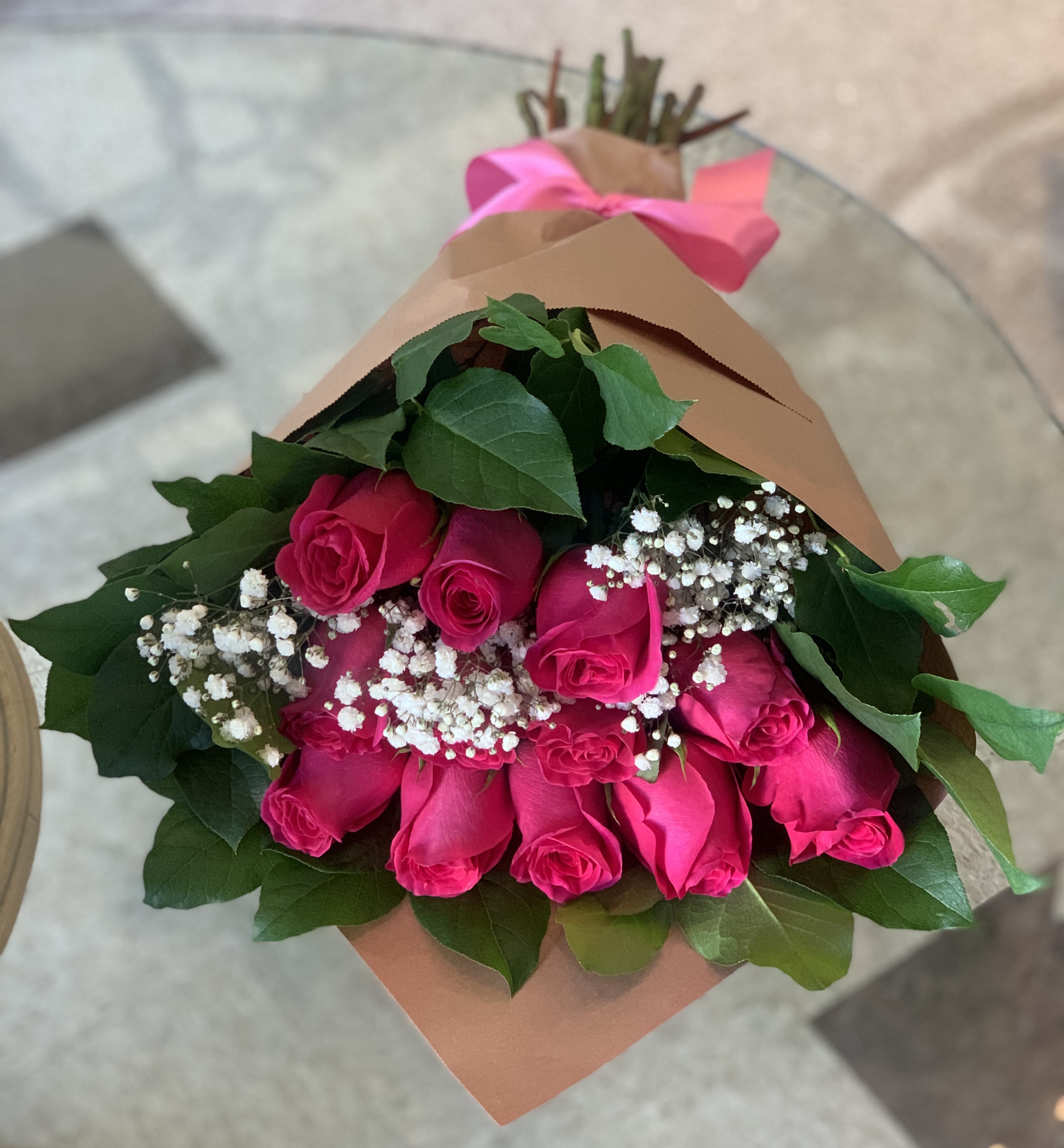One Dozen Pink Rose Bouquet - One dozen pink roses, wrapped, accompanied by greenery and babies breath. Upgrade to deluxe for 18, or premium for 2 dozen roses.