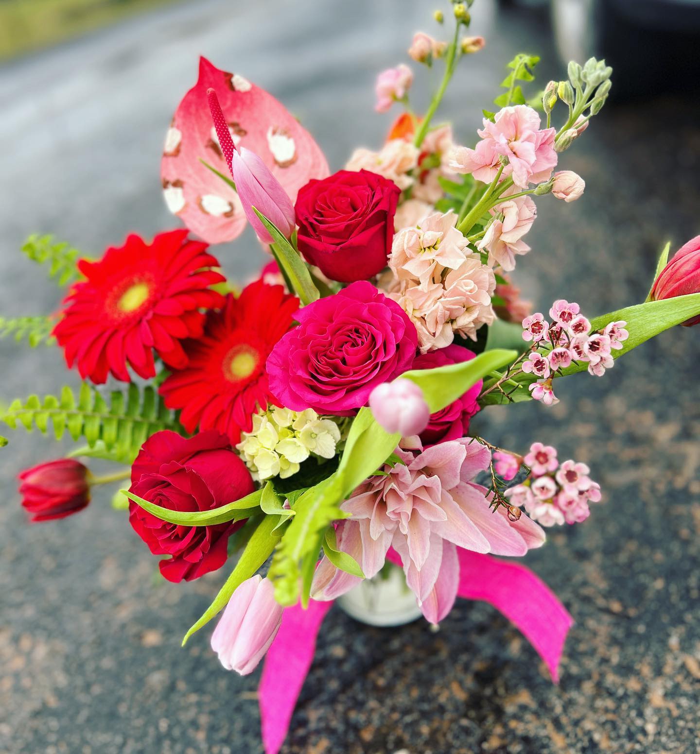 Valentine's Day Pink Cheetah - A romantic blend of passion and softness, this Valentine’s Day arrangement is designed to make hearts skip a beat. Vibrant red roses take center stage, symbolizing deep love and devotion, beautifully balanced with delicate blush stock, pink cheetah print Anthurium, and fresh seasonal accents. Artfully arranged in a modern container, this design feels both timeless and elevated.  Perfect for Valentine’s Day, anniversaries, or simply reminding someone how loved they are, this arrangement delivers classic romance with a fresh, feminine touch. Each piece is handcrafted with premium blooms to create a lush, full presentation that feels as special as the sentiment behind it.   Limited Valentine’s Day availability. Order early to ensure delivery. 