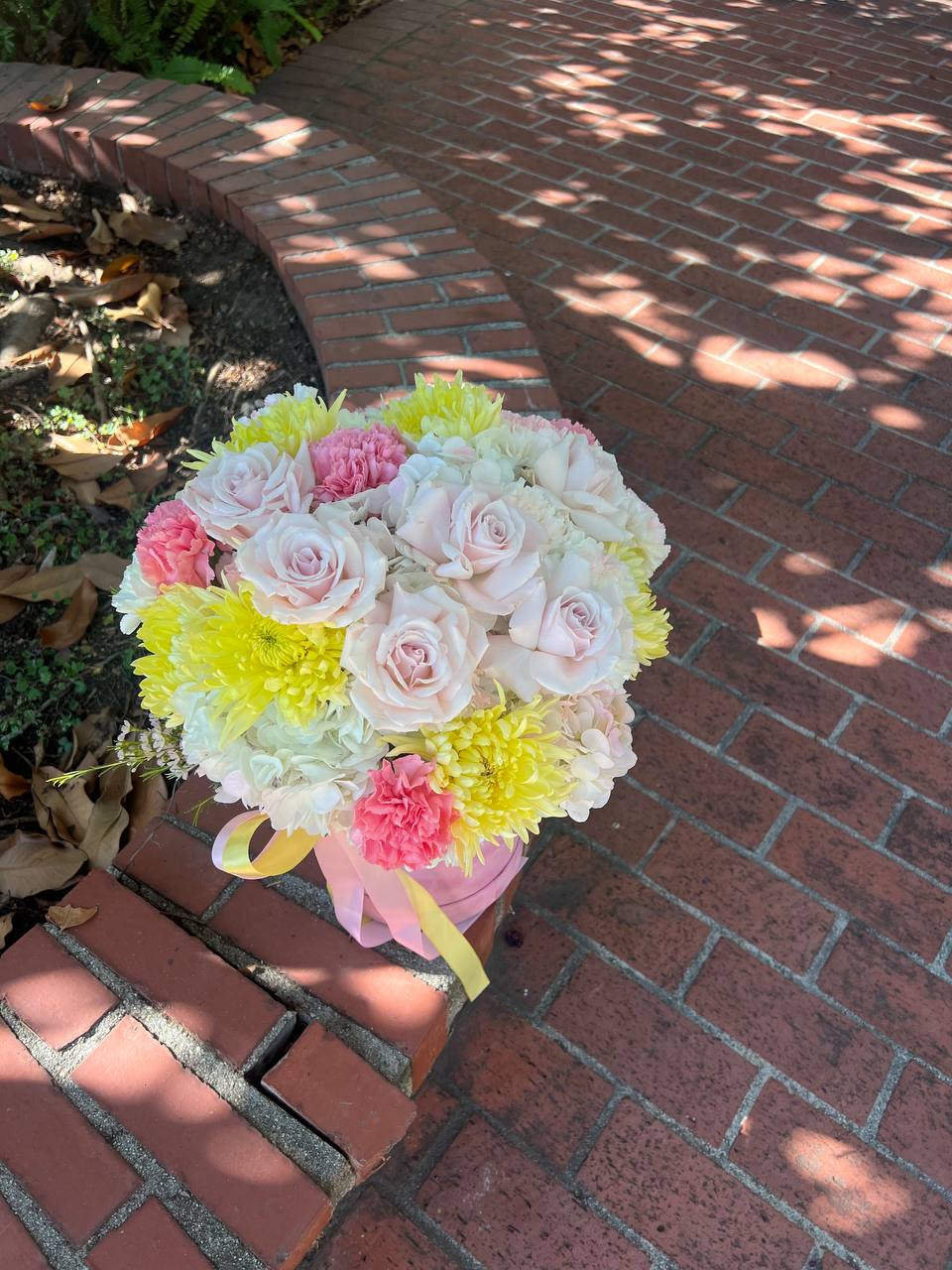 Ameli - Ameli is the embodiment of tenderness and elegance. Soft pastel pink roses intertwine with airy white and sunny yellow chrysanthemums, creating a sense of freshness and joy. The delicate color transitions resemble the morning light, enveloping everything in warmth and serenity. Graceful ribbons add a touch of lightness, emphasizing its refined and romantic character.  This bouquet is like a gentle whisper of spring, awakening the warmest emotions. A perfect gift to express love, care, and admiration.