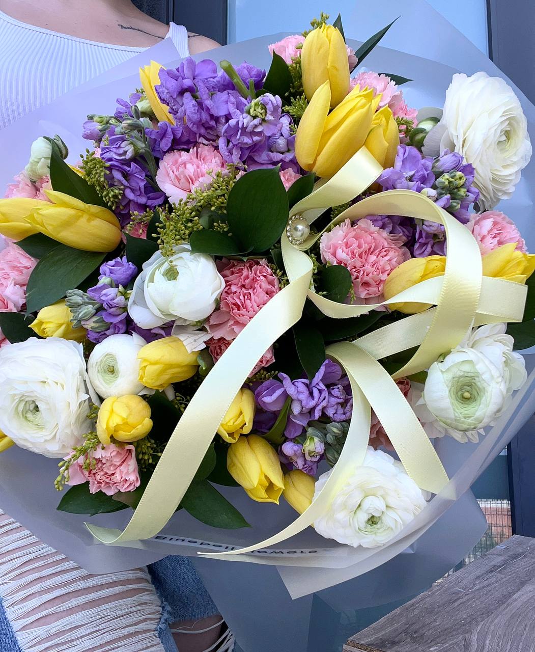 Spring Melody - A cheerful and elegant mix of yellow tulips, soft pink carnations, fragrant purple matthiola, and delicate white ranunculus. This bouquet feels like the first warm morning of spring — full of light, color, and gentle joy.  Perfect for birthdays, thank-you’s, or simply to brighten someone’s day. Handcrafted with fresh blooms and heart.   