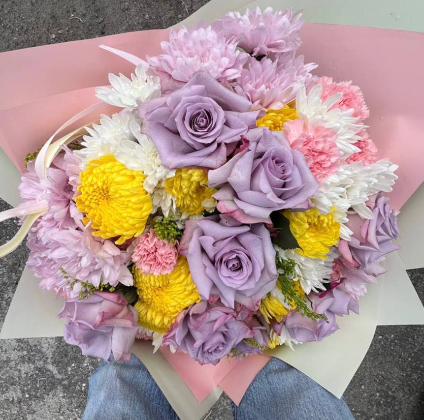 Pastel Watercolor - This bouquet combines delicate pastel shades of lilac, pink, and yellow, creating a light and romantic atmosphere. Lavender roses add an elegant touch, while yellow and white chrysanthemums bring bright, sunny accents and a sense of freshness. The entire composition feels like a watercolor painting, with each hue blending seamlessly into the next for a harmonious and uplifting display.