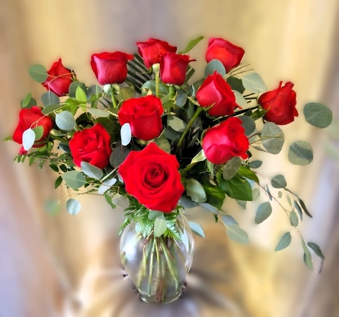 One Dozen Elegant Red Roses ~ Flower A Day - One Dozen Elegant Red Roses is a stunning flower arrangement that exudes timeless elegance and sophistication. This luxurious arrangement features 12 of the finest long-stemmed red roses, expertly arranged in a classic vase to showcase their natural beauty and grace. The rich red hue of the roses symbolizes deep love, passion, and admiration, making it the perfect gift for a special someone on any occasion. Whether you're looking to make a grand romantic gesture or simply want to express your love and appreciation, One Dozen Elegant Red Roses is the perfect choice.