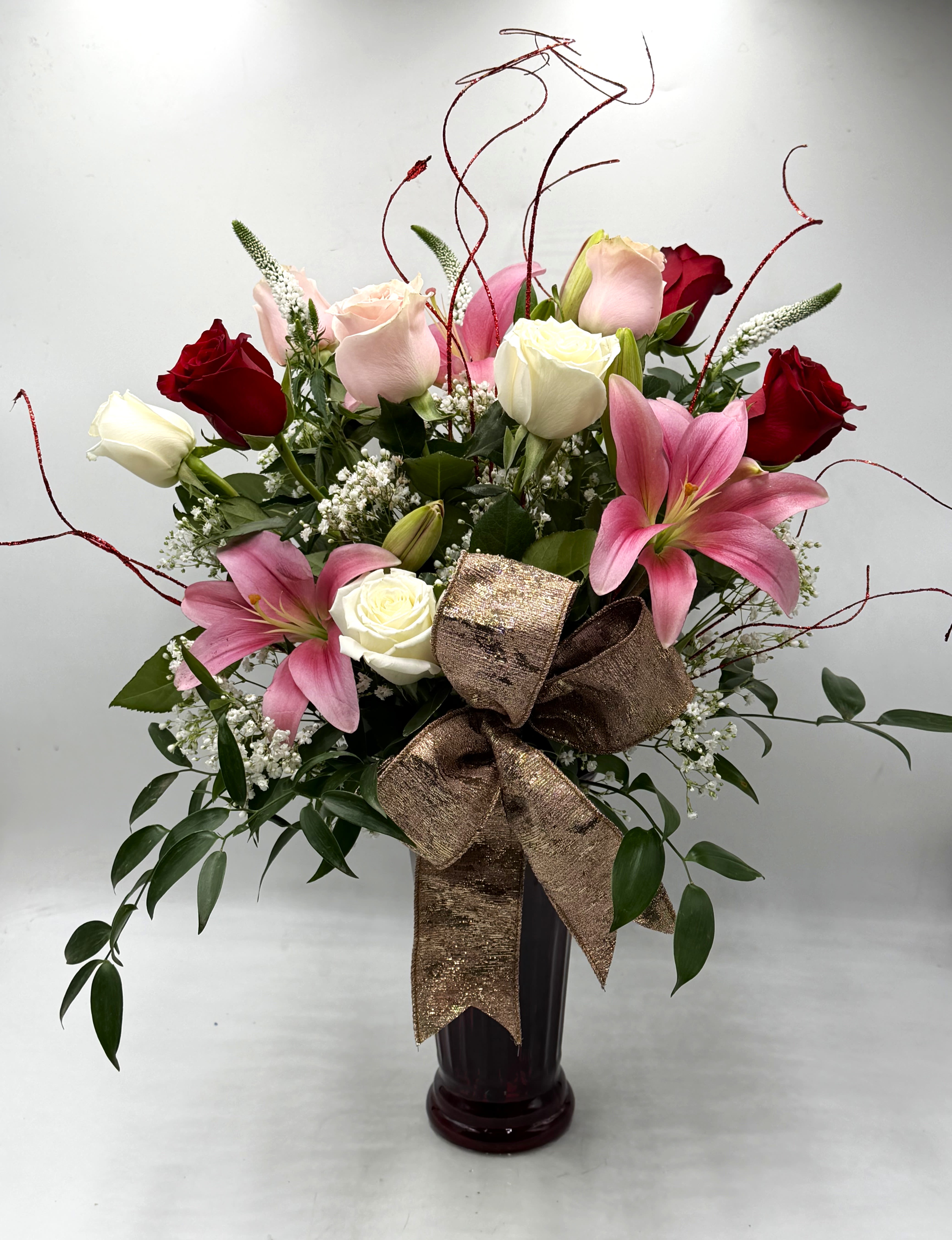 Timeless Romance - Romance meets elegance in this stunning Valentine's bouquet of red, blush &amp; white roses paired with graceful pink lilies, designed in a ruby vase and finishes off with an elegant pink and gold bow. It's a heartfelt way to say ' I Love You ' !!